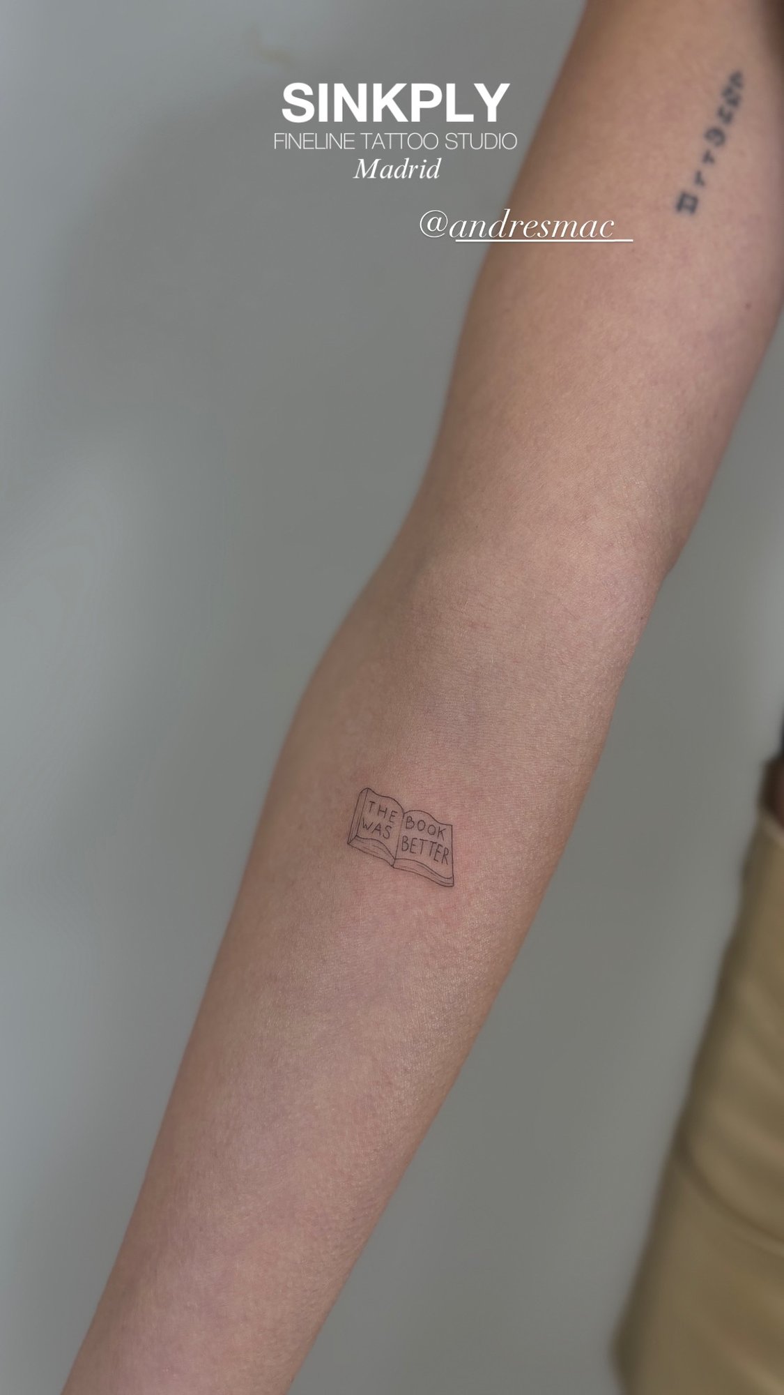 Tatuaje de libro abierto the book was bet en antebrazo, línea fina