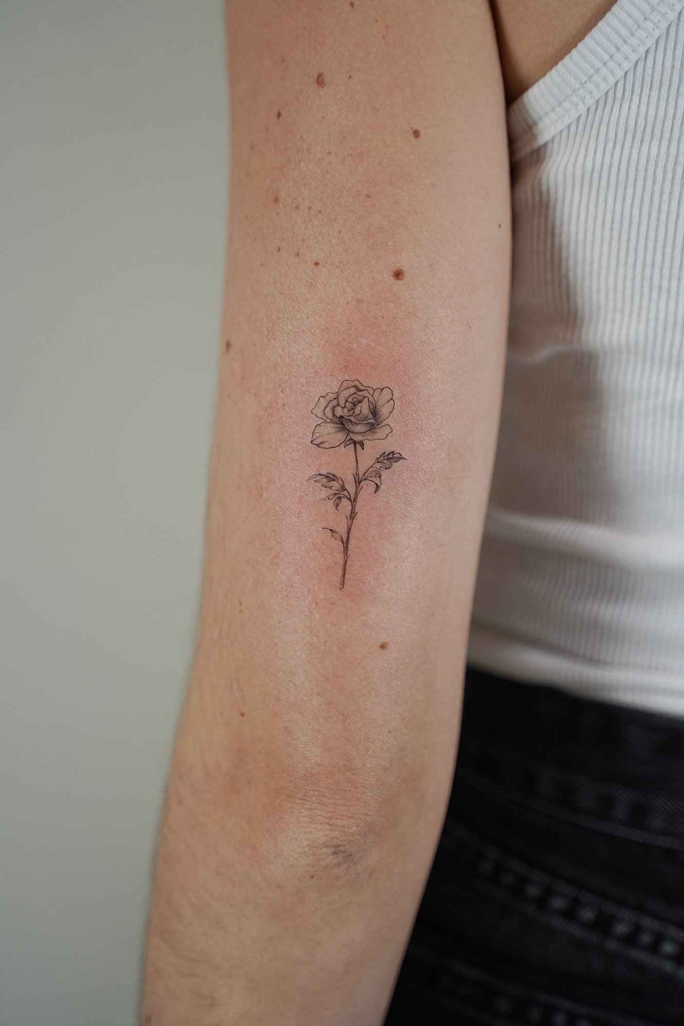 Tatuaje de nombre cursiva en codo, línea fina