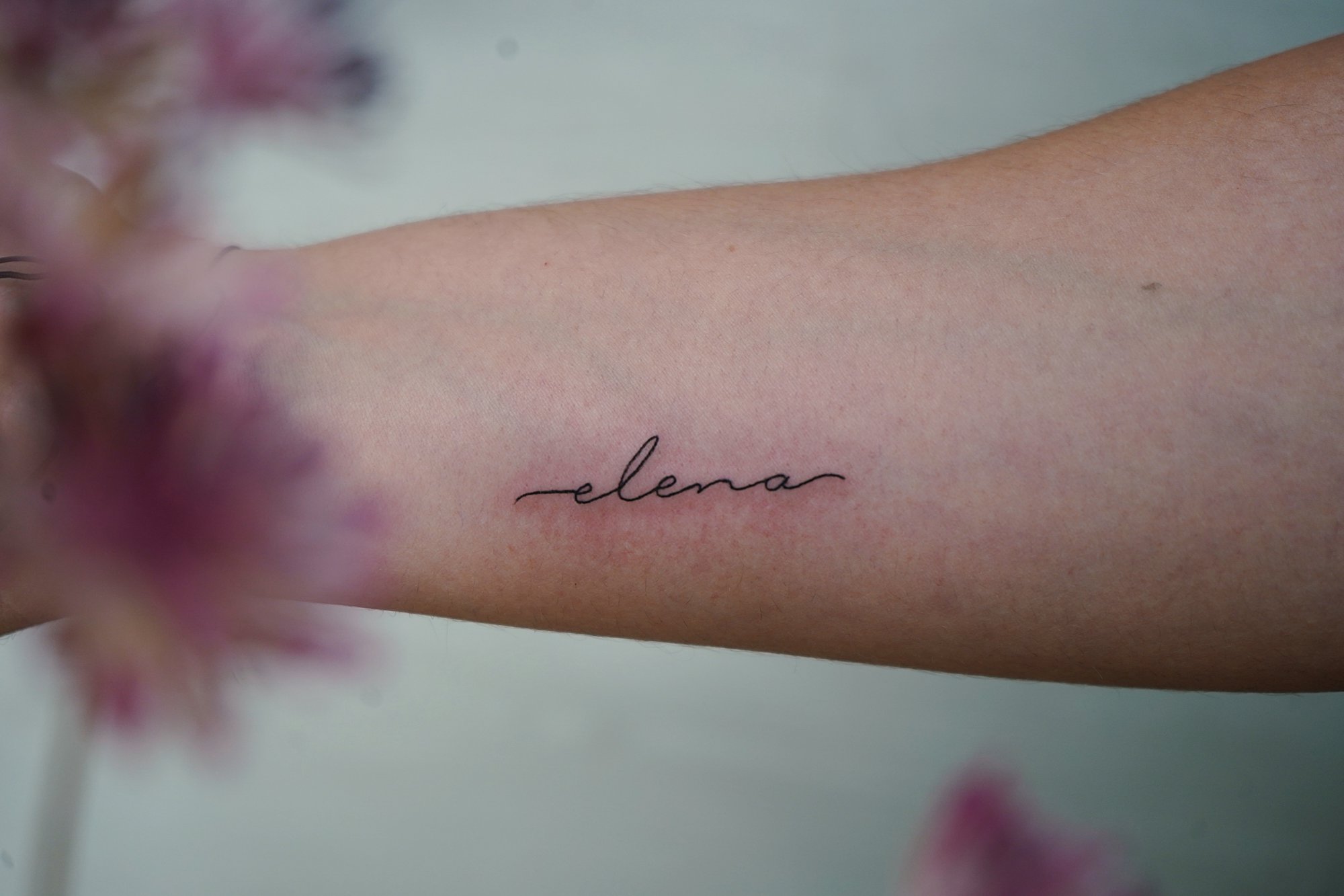 Tatuaje de nombre en zona desconocida, línea fina