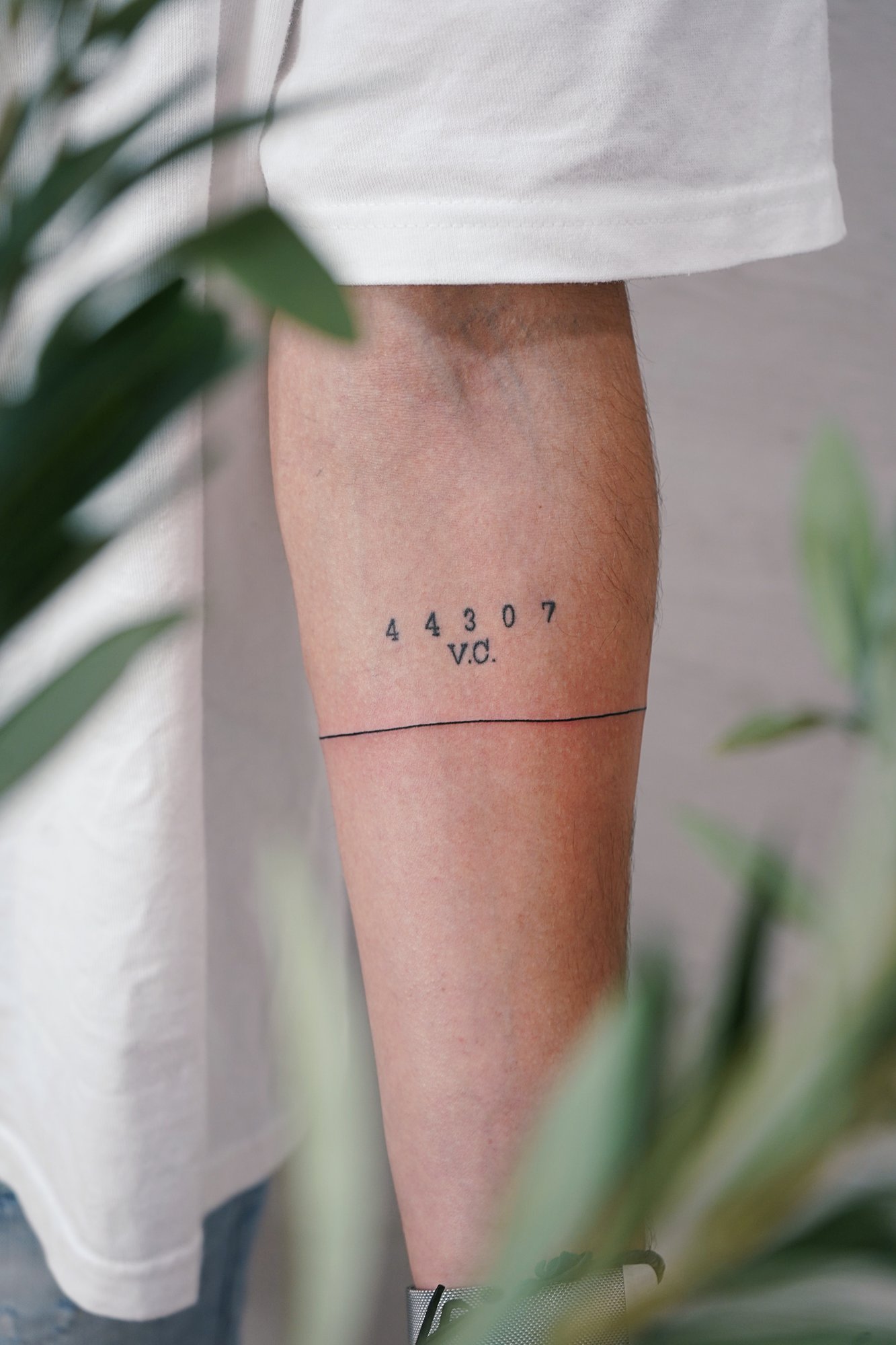 Tatuaje de numero linea en brazo, línea fina