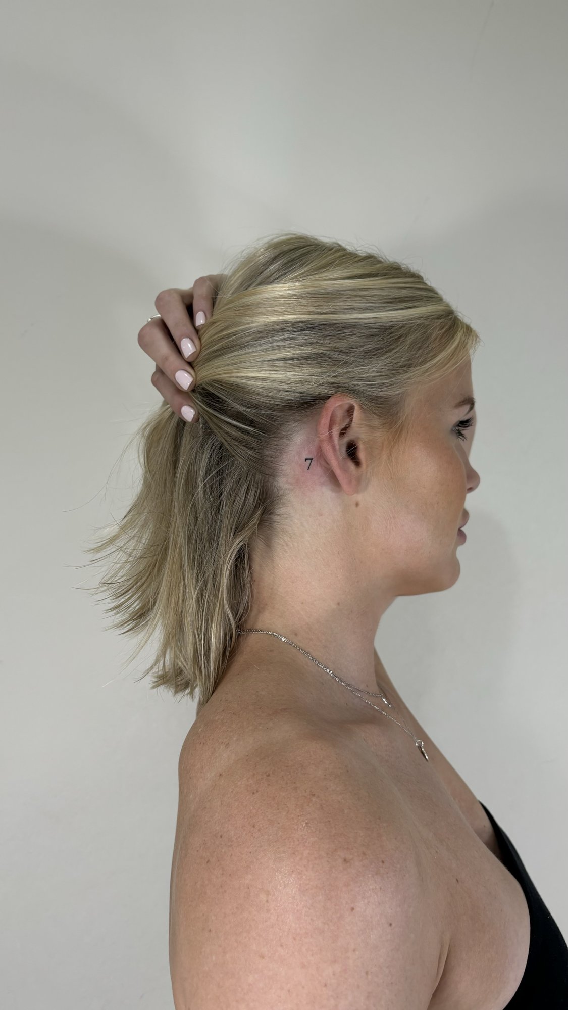Tatuaje de numero siete detras oreja en detras oreja, línea fina
