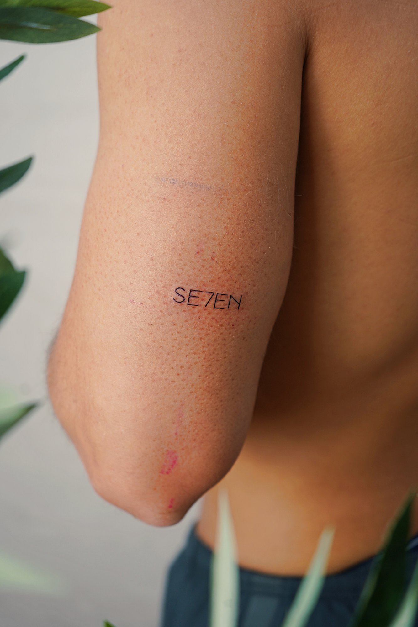Tatuaje de numero siete en codo, línea fina