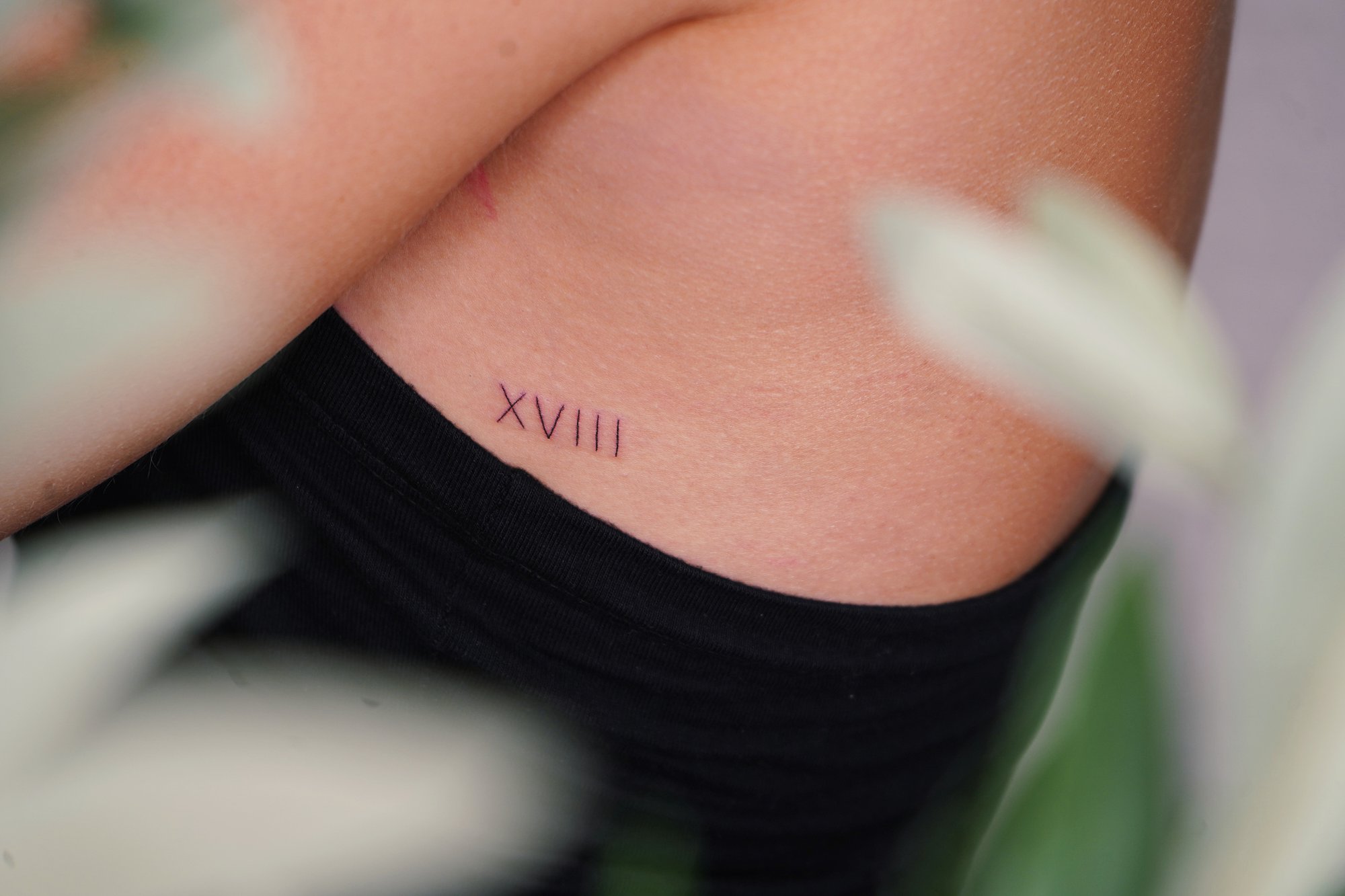 Tatuaje de numeros romanos en costilla, línea fina