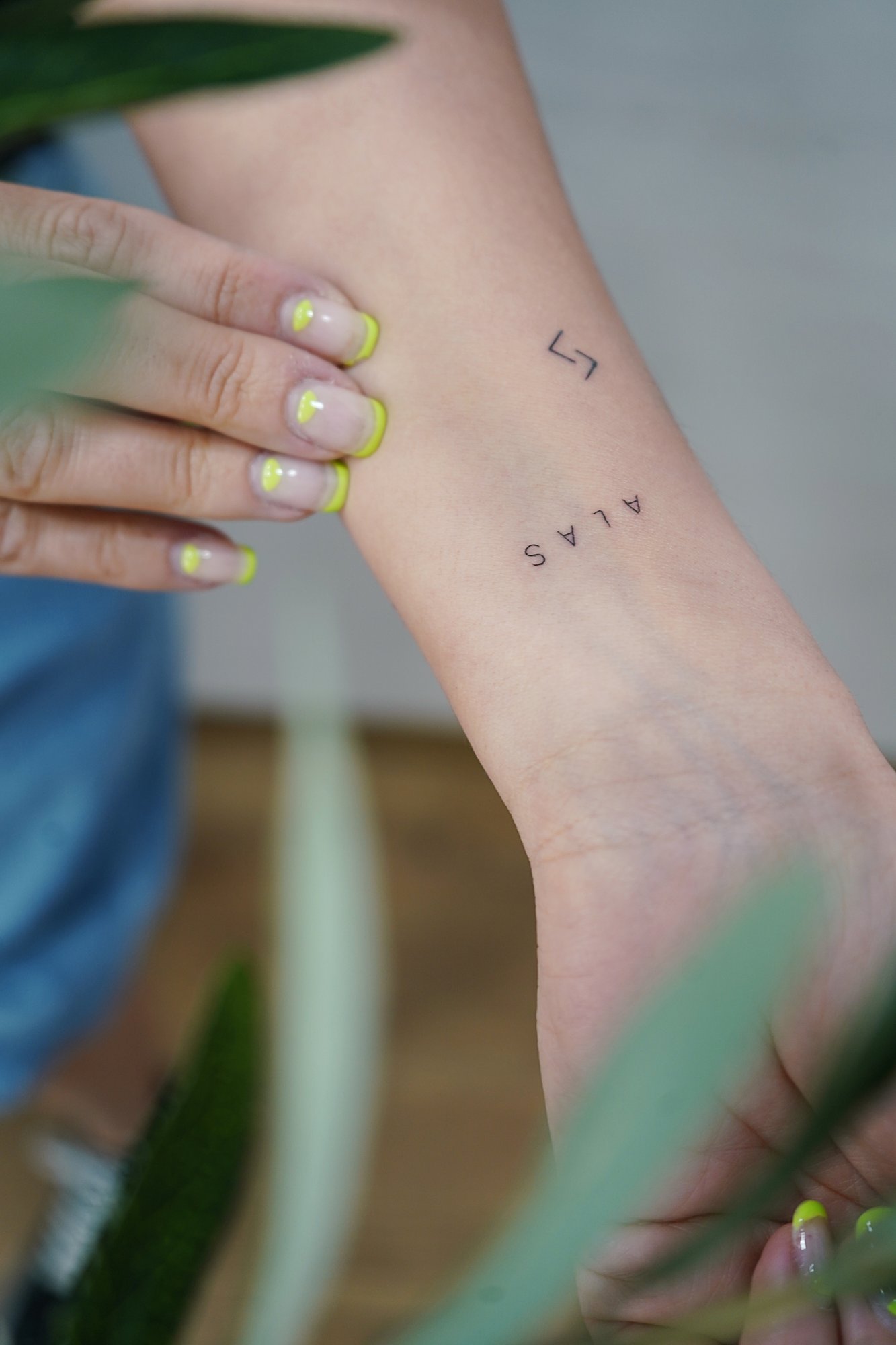 Tatuaje de palabra alas en muneca, línea fina