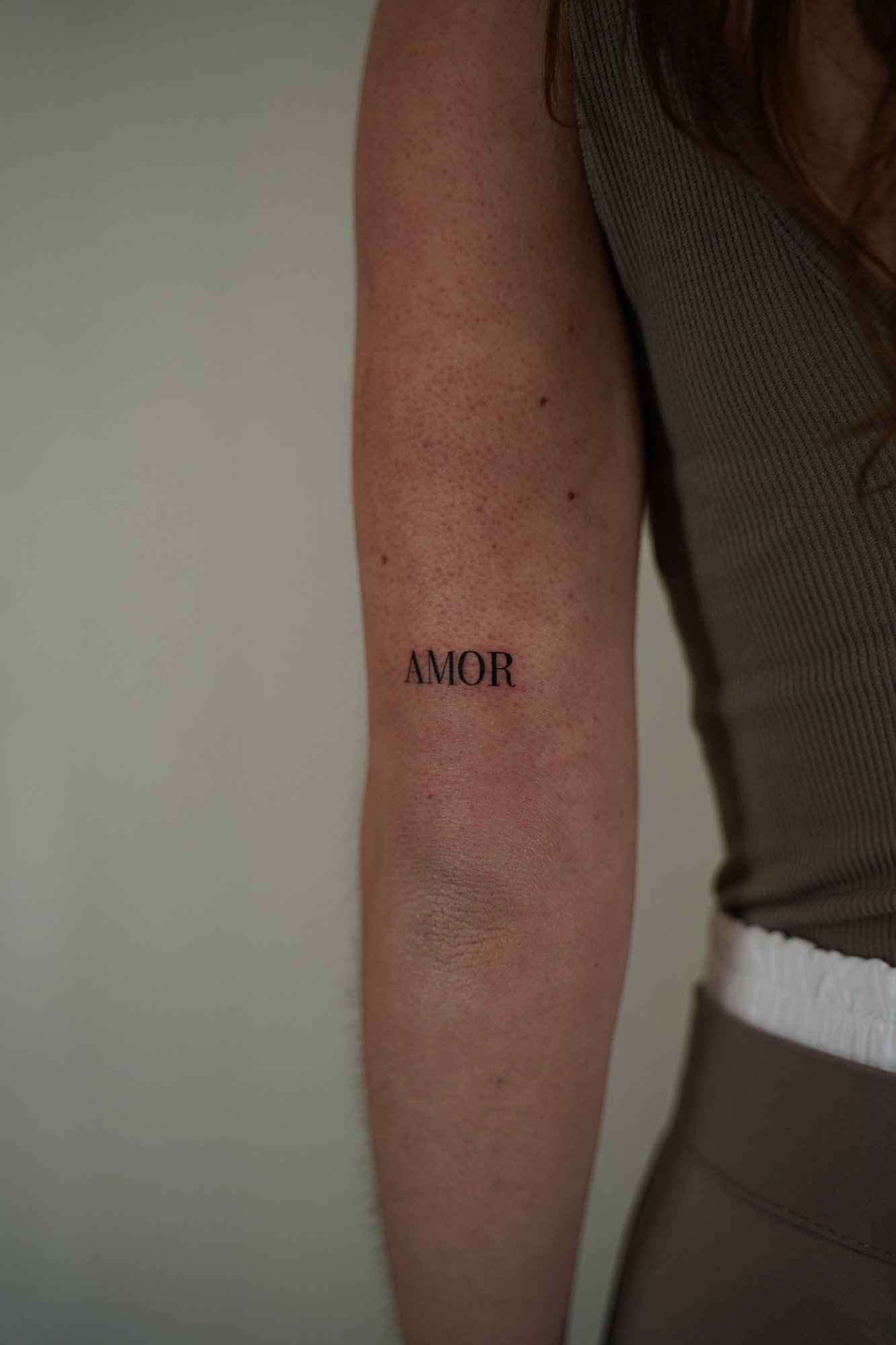 Tatuaje de palabra amor en zona desconocida, línea fina