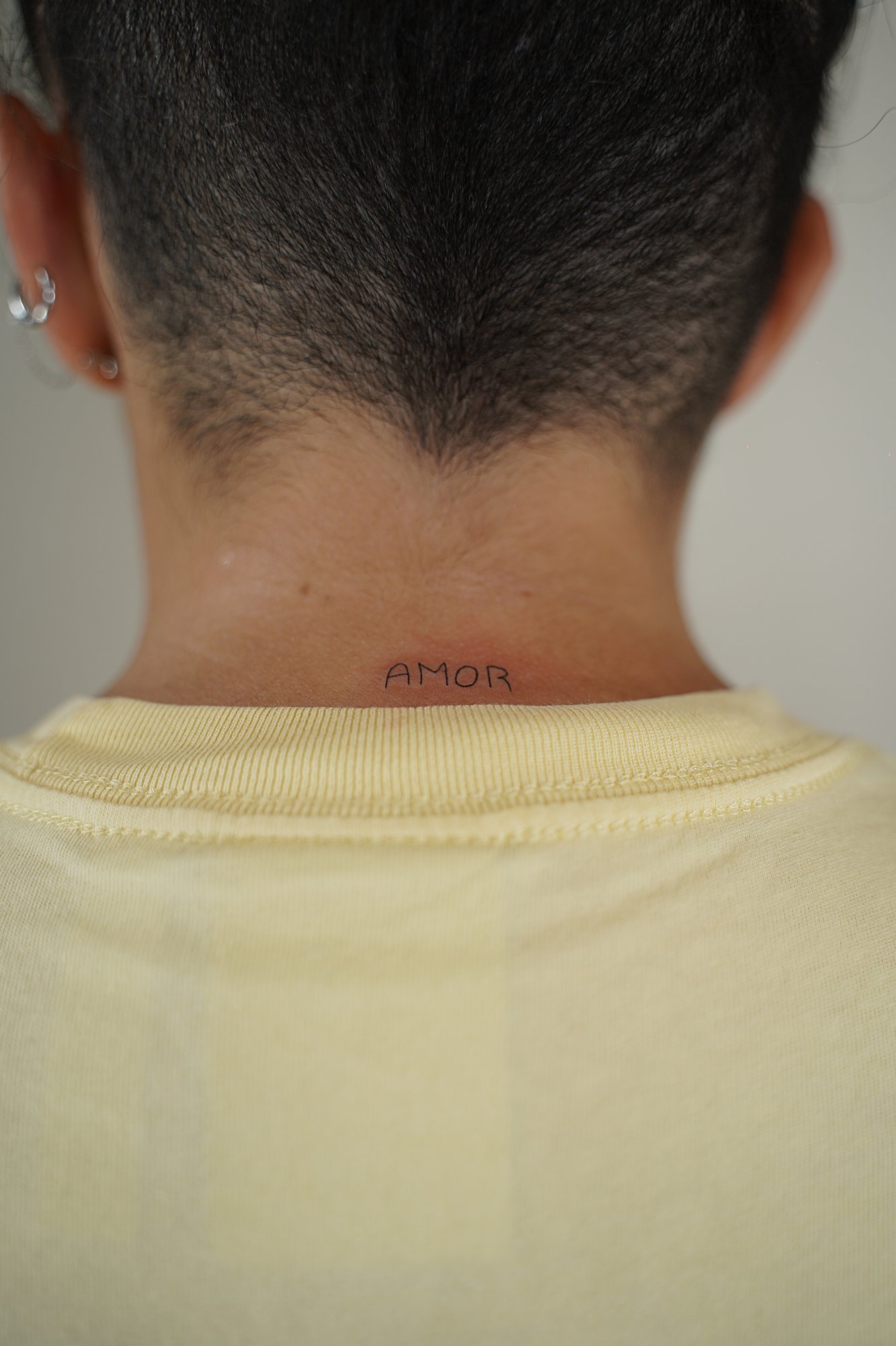 Tatuaje de palabra amor en zona desconocida, línea fina