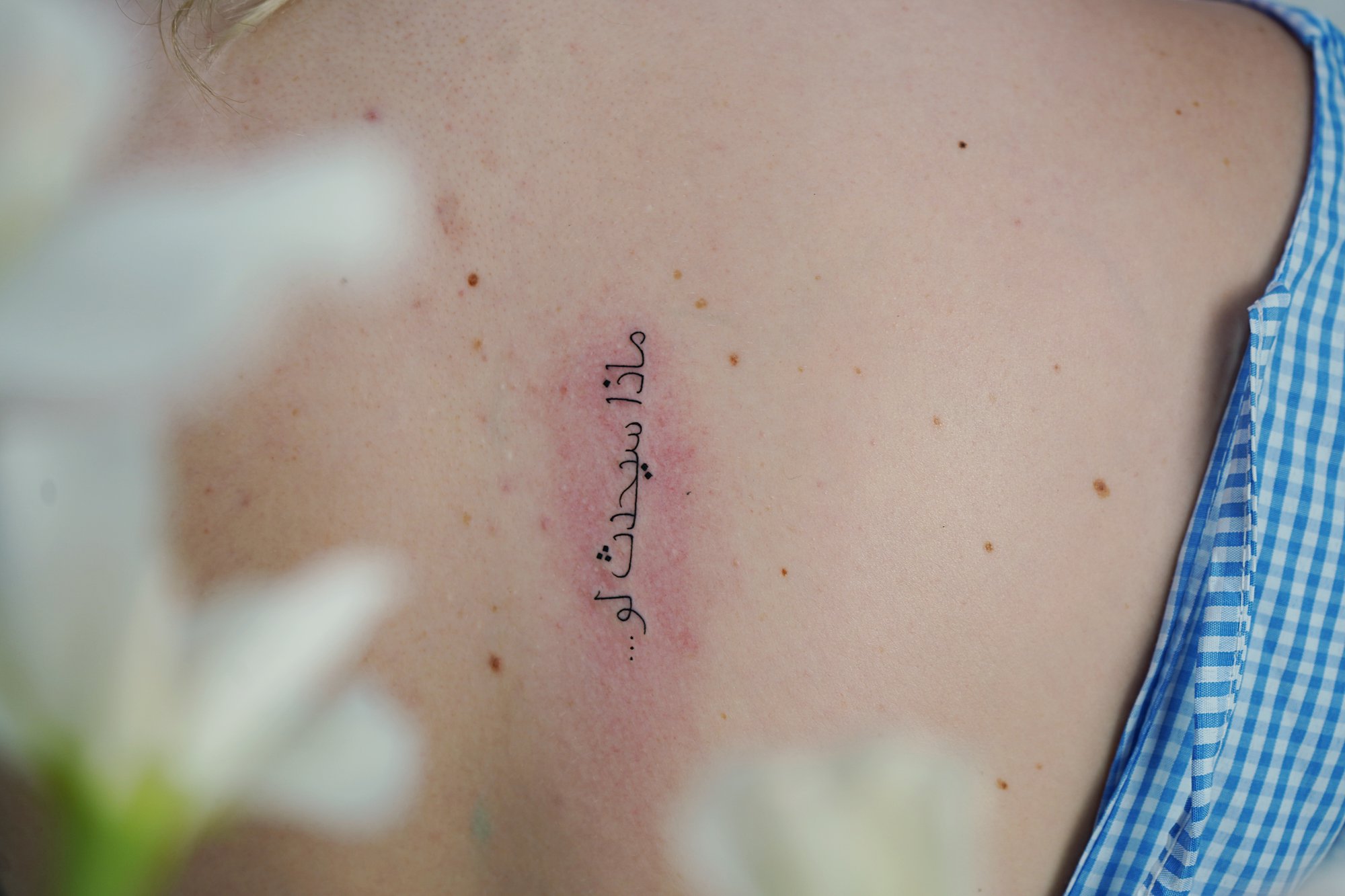 Tatuaje de palabra arabe en costilla, línea fina