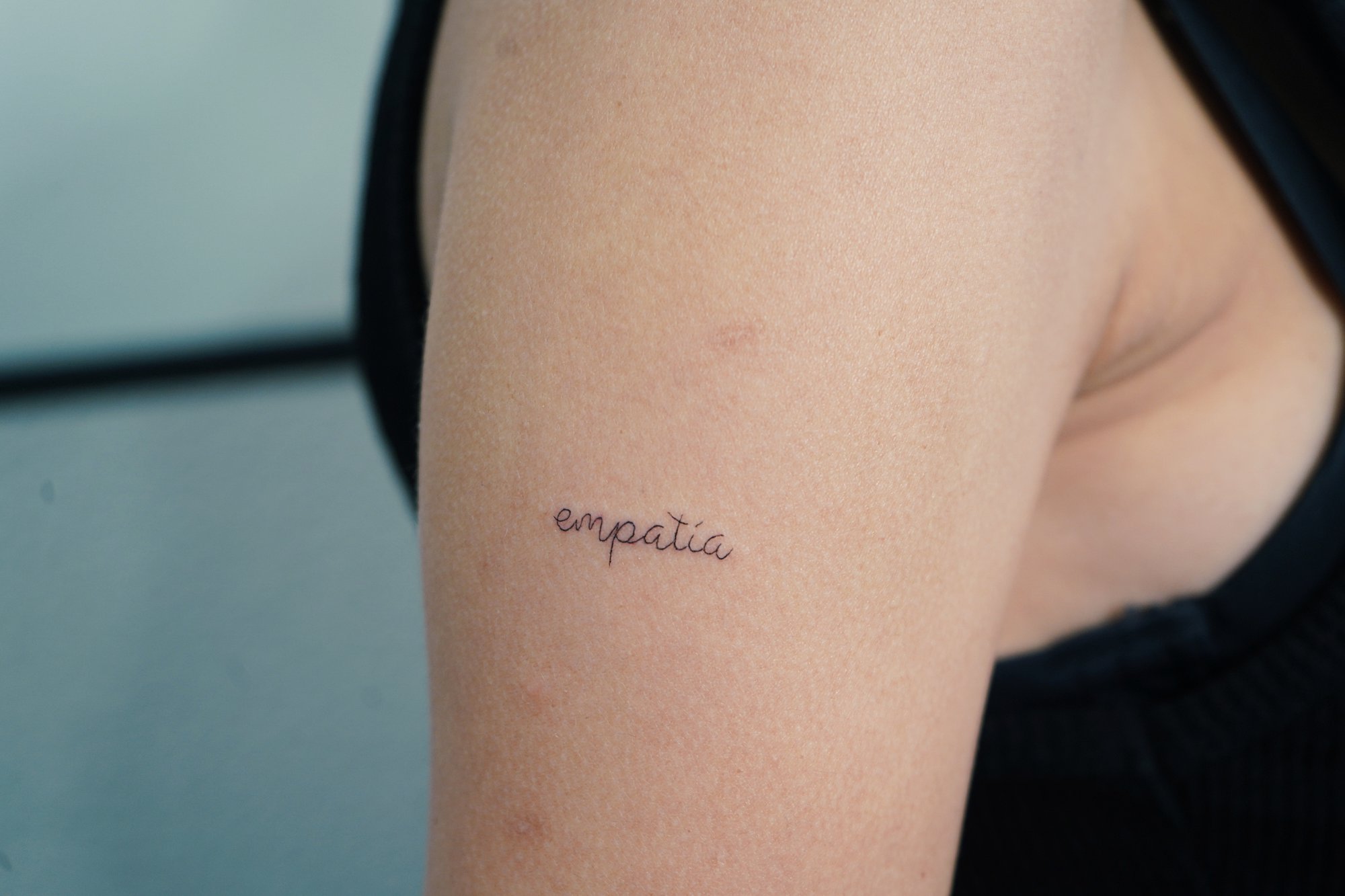 Tatuaje de palabra empatia en brazo, línea fina