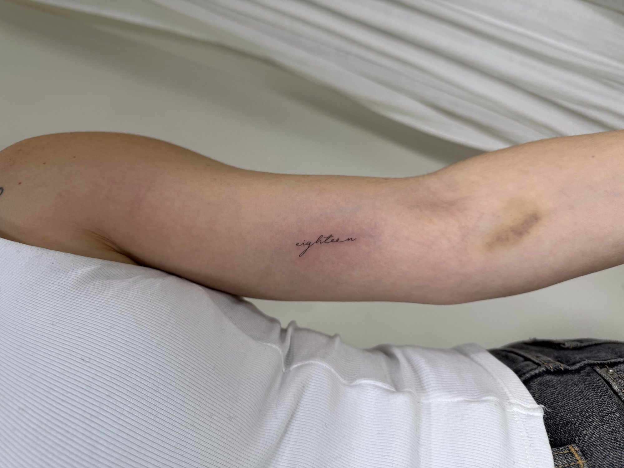 Tatuaje de palabra golden cursiva fina en brazo, línea fina