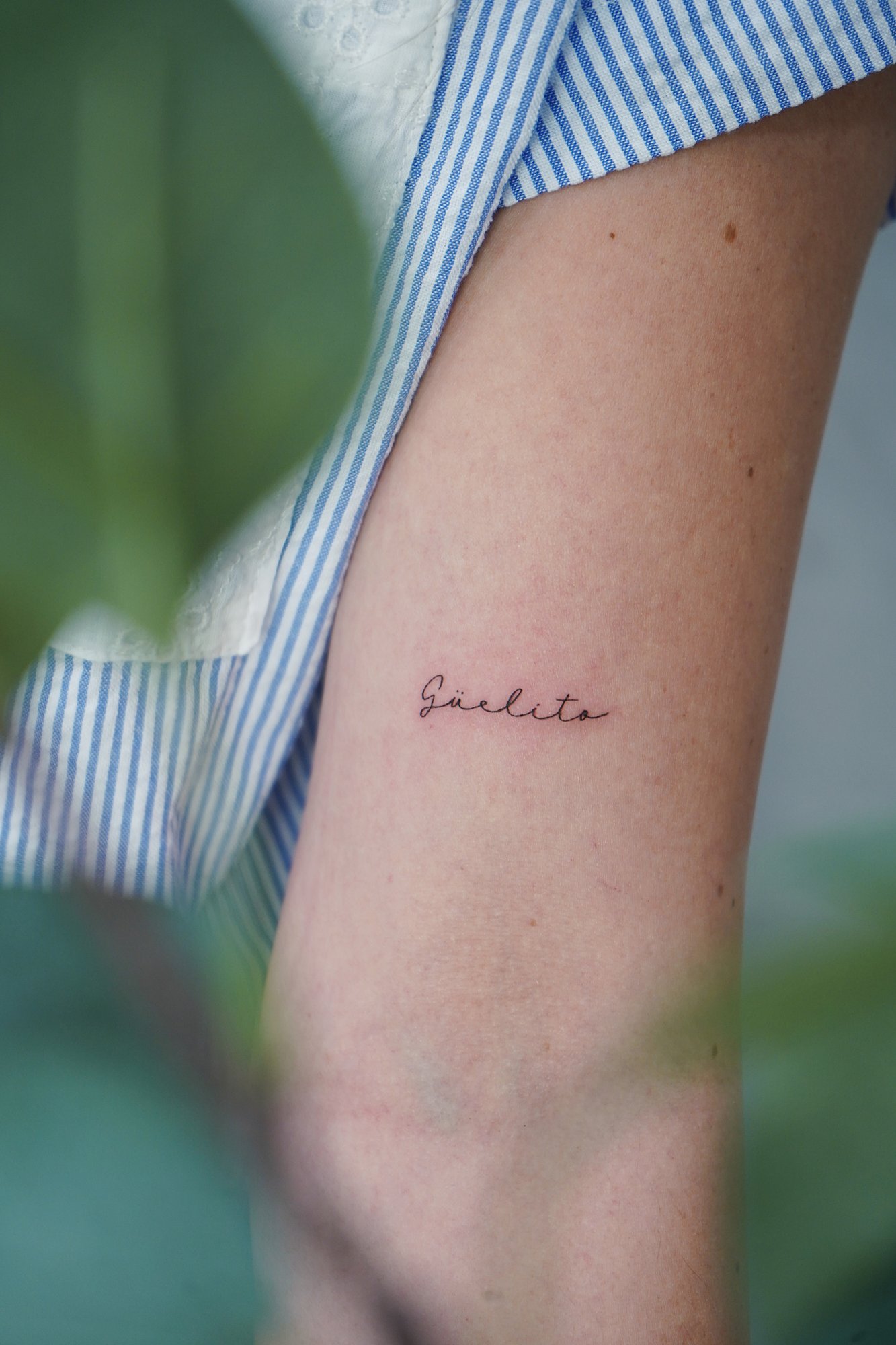 Tatuaje de palabra guelito en brazo, línea fina