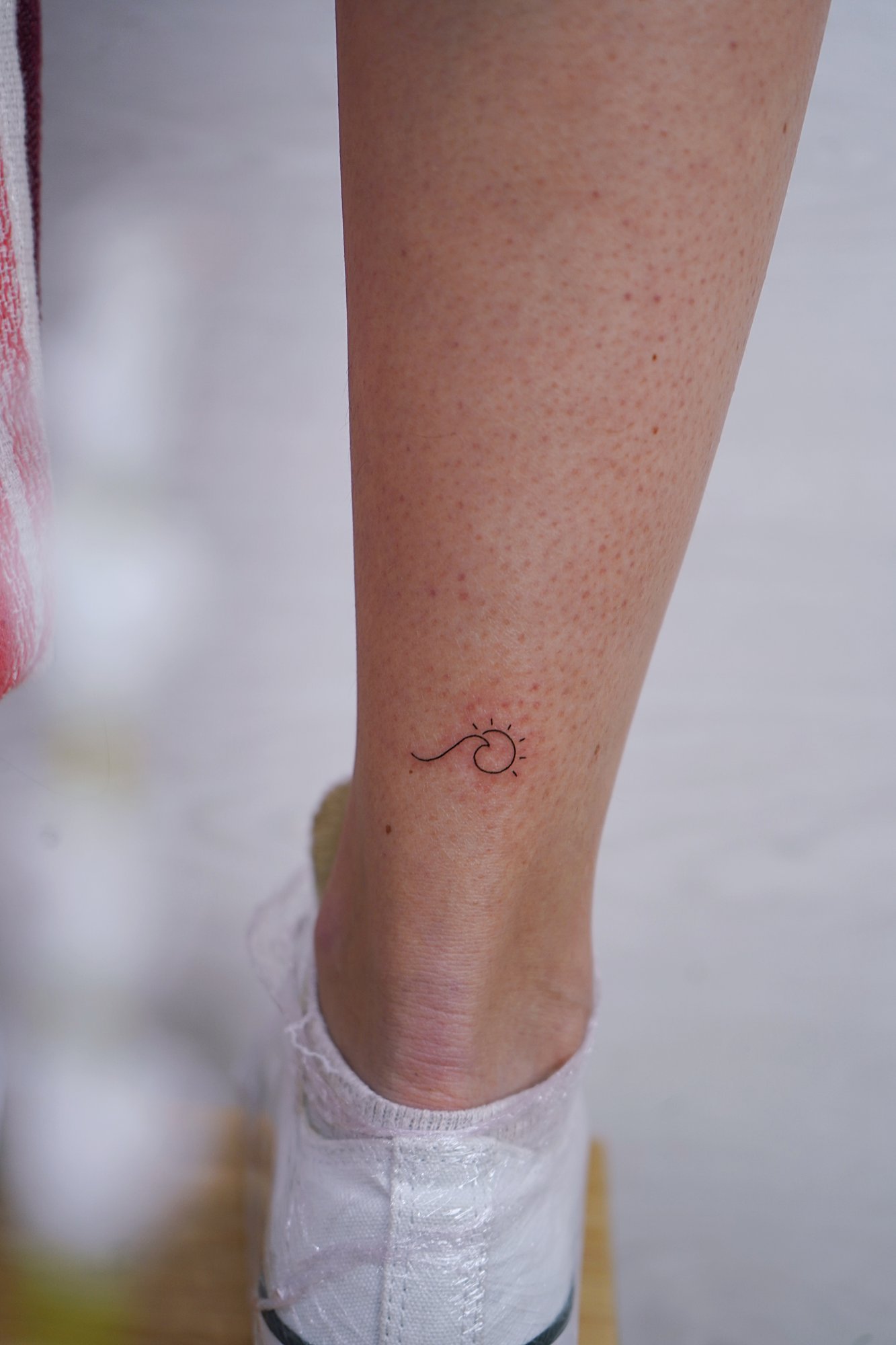 Tatuaje de palabra hola en tobillo, línea fina