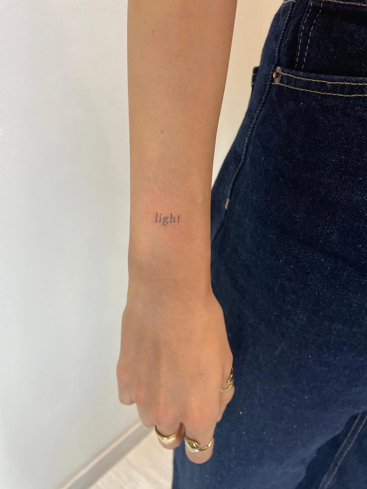 Tatuaje letras-frases palabra light cursiva antebrazo