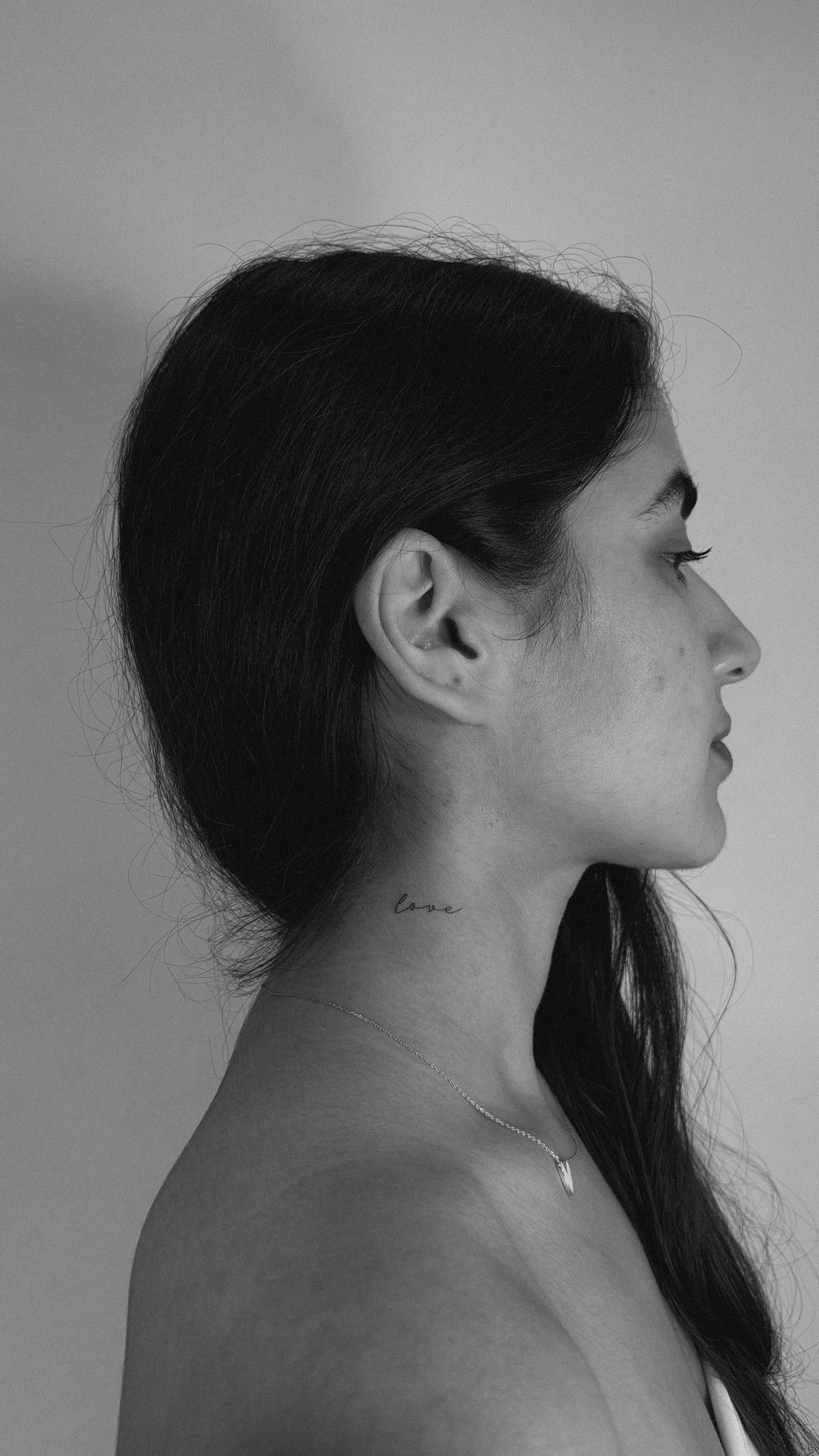 Tatuaje de palabra love cursiva cuello en cuello, línea fina