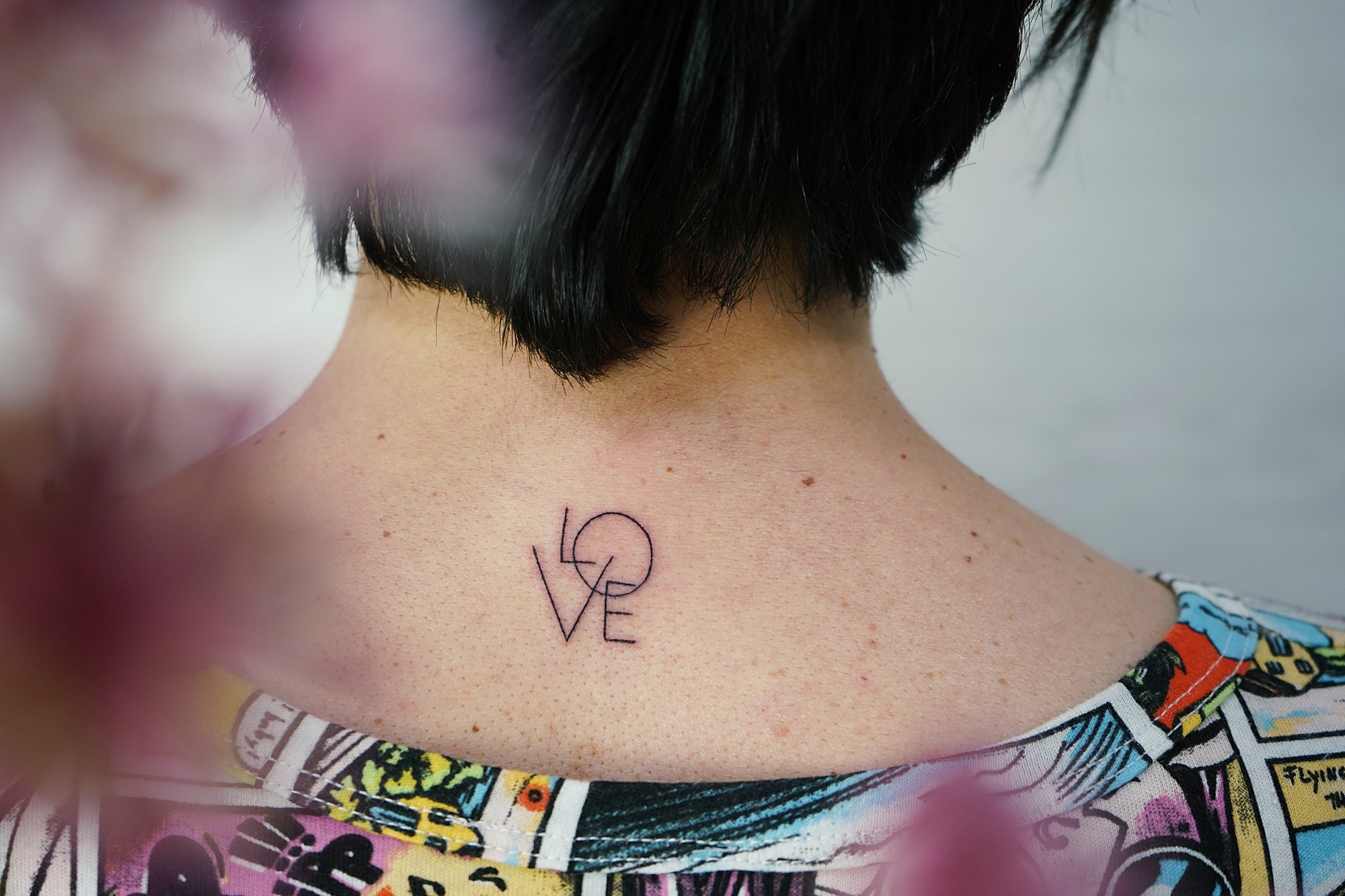Tatuaje de palabra love en nuca, línea fina