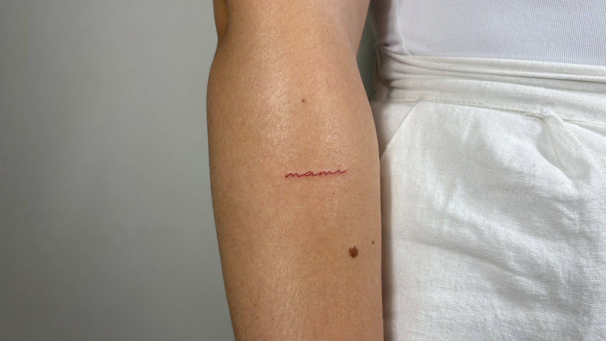 Tatuaje de palabra mami rojo en zona desconocida, línea fina