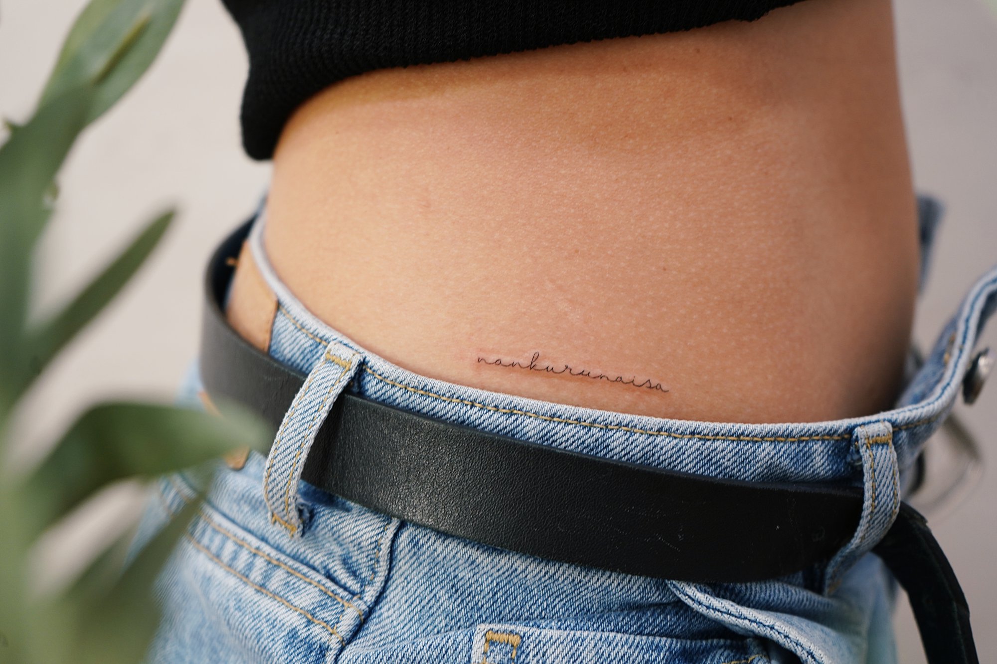 Tatuaje de palabra nakurunaisa en cadera, línea fina