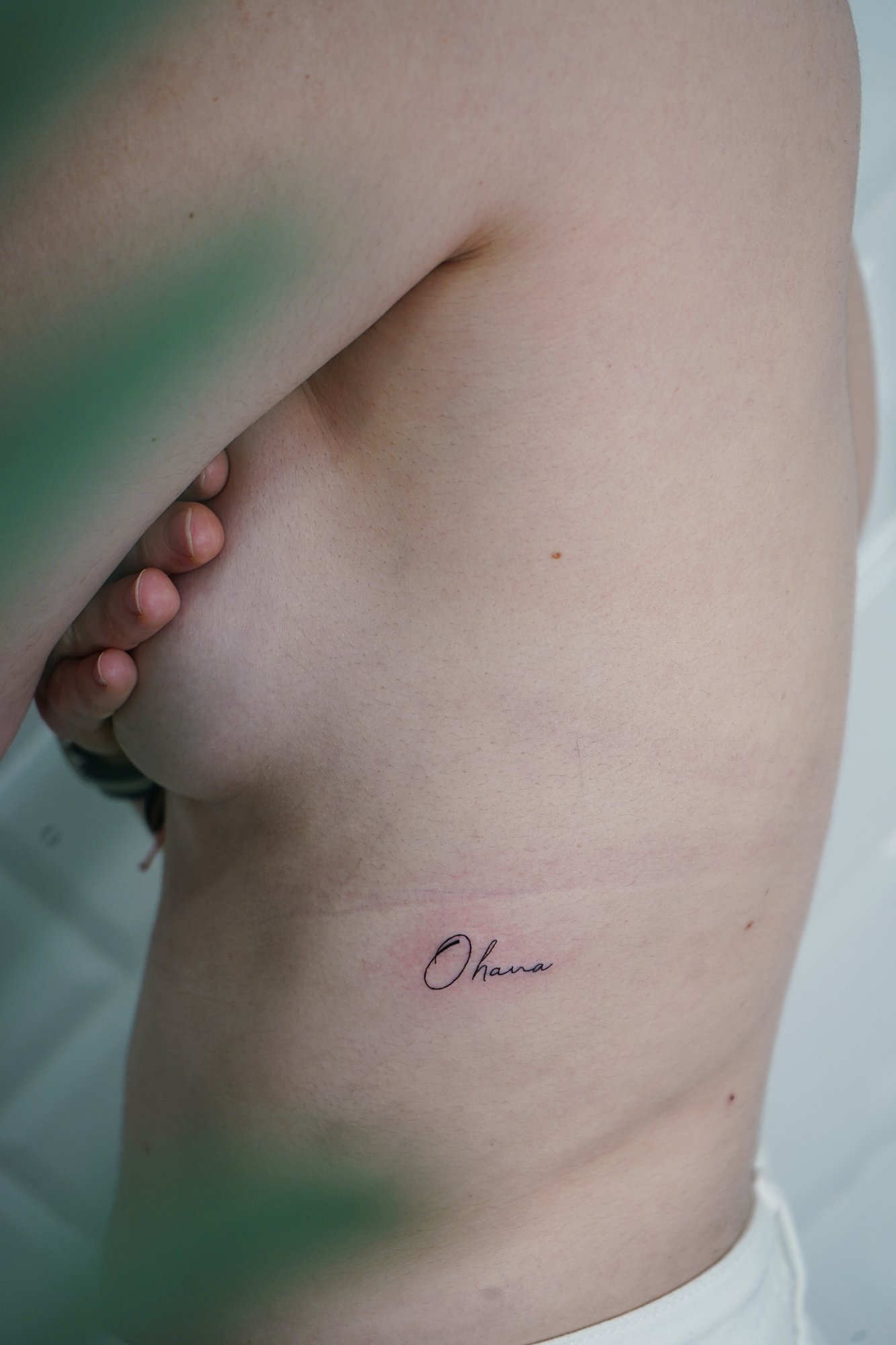 Tatuaje de palabra ohana en costilla, línea fina