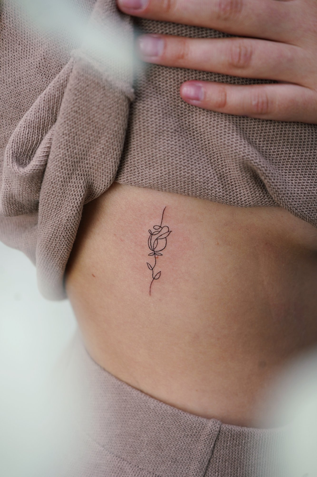 Tatuaje de palabra serendipia en costilla, línea fina