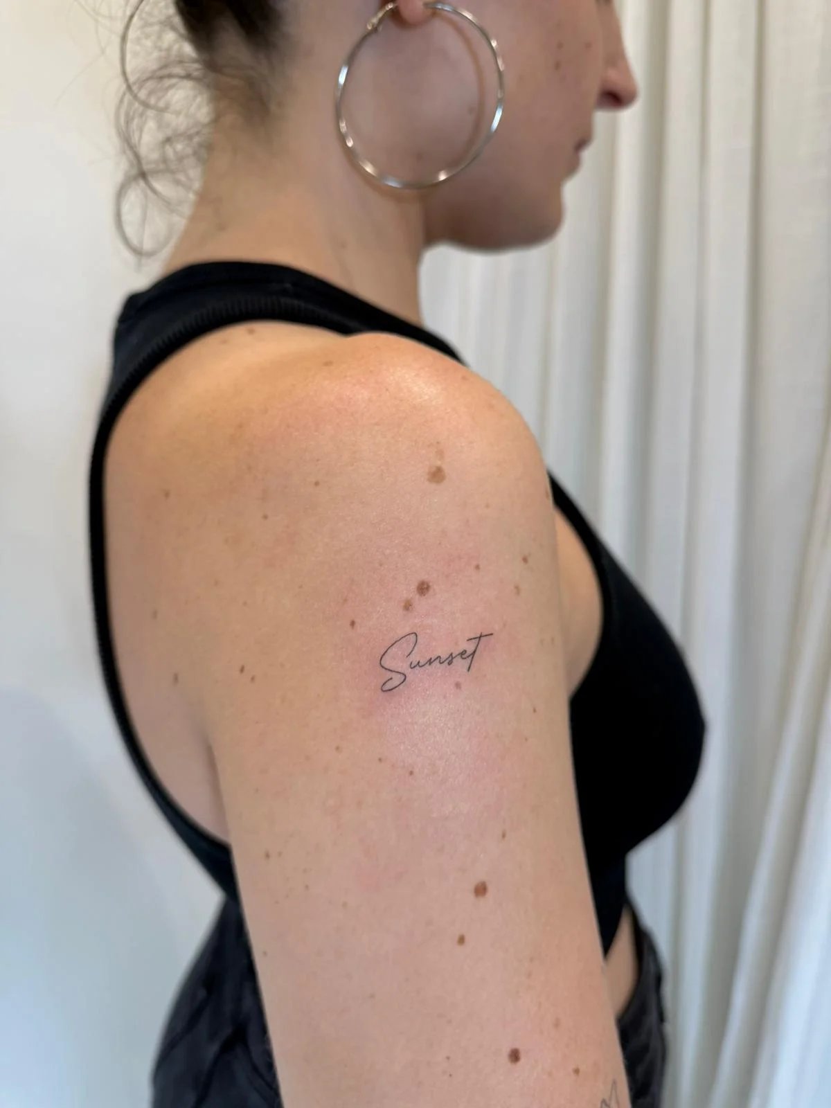 Tatuaje letras-frases palabra sunset cursiva hombro
