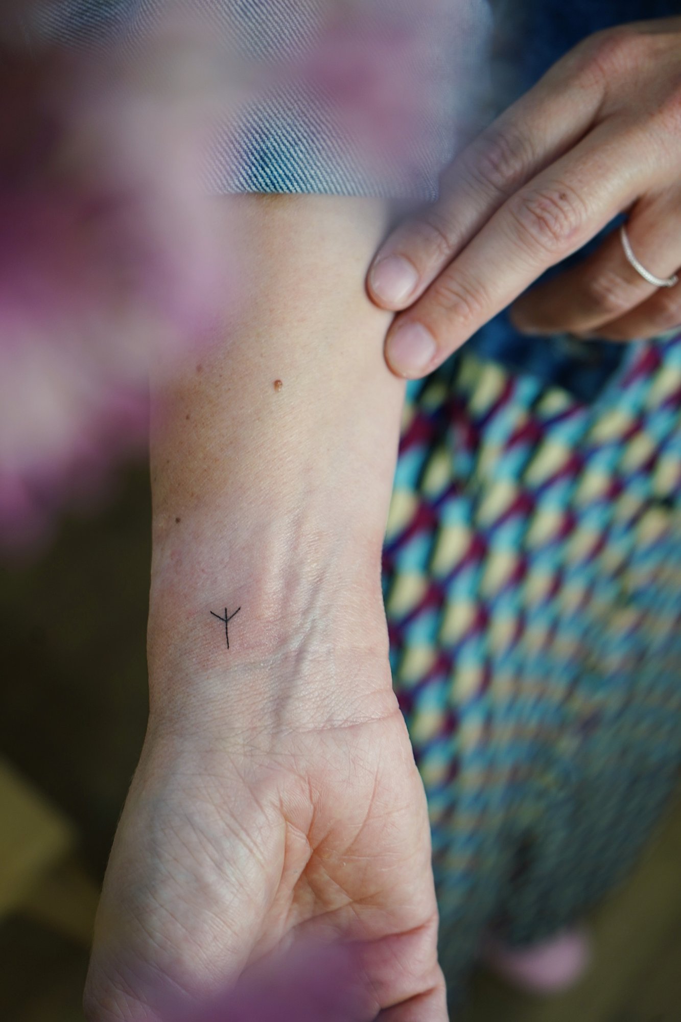 Tatuaje de palabra en antebrazo, línea fina
