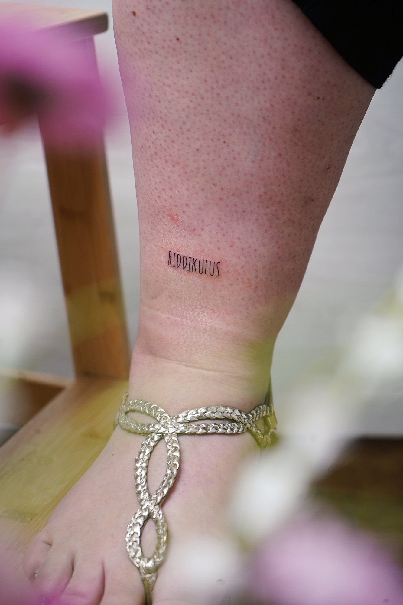 Tatuaje de palabra en tobillo, línea fina