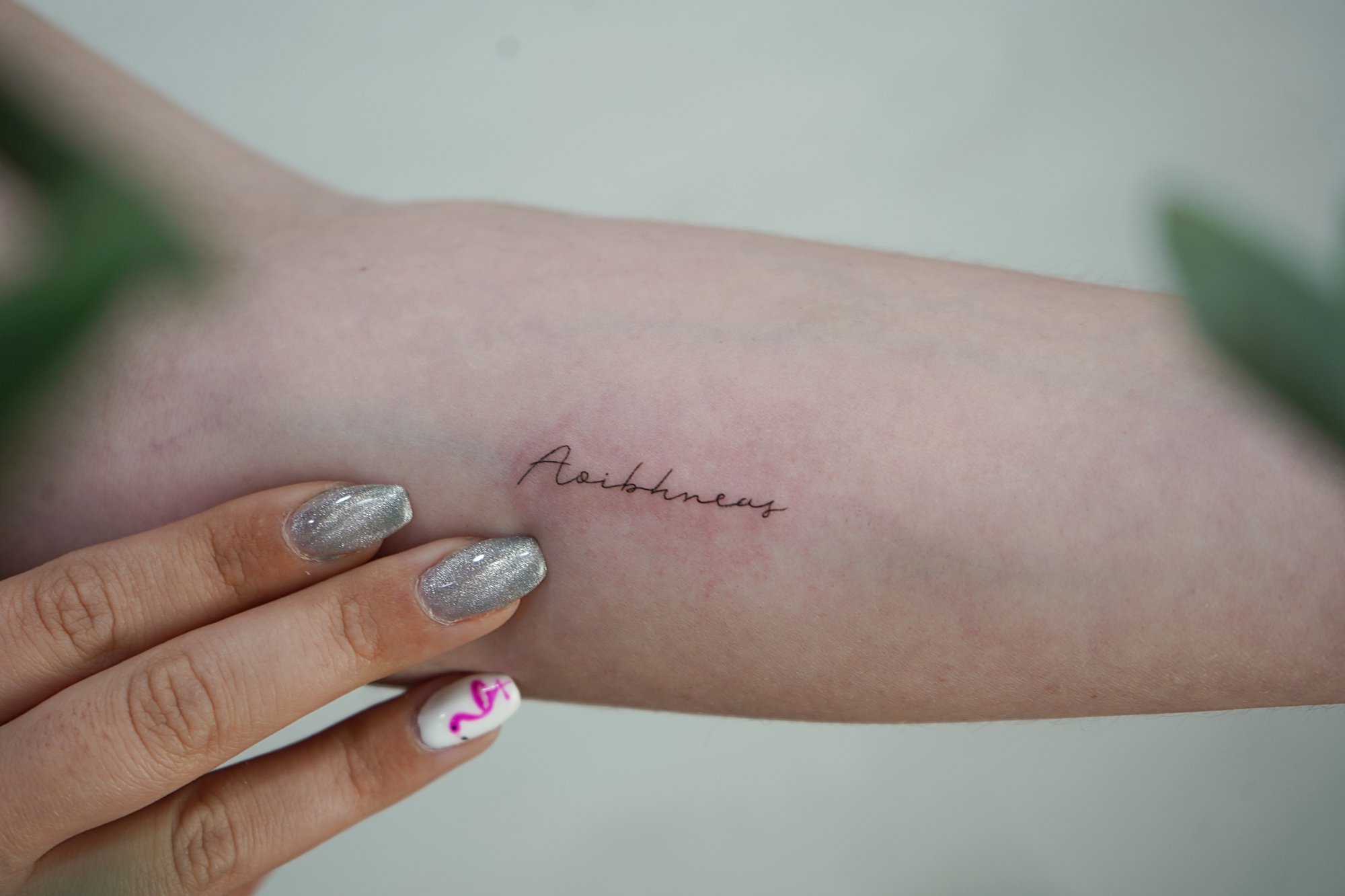 Tatuaje de palabras en antebrazo, línea fina