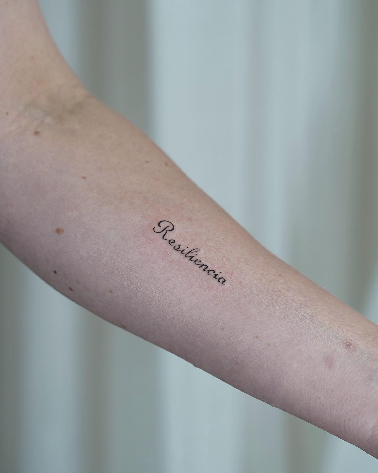 Tatuaje de frase en antebrazo, línea fina Sinkply Madrid