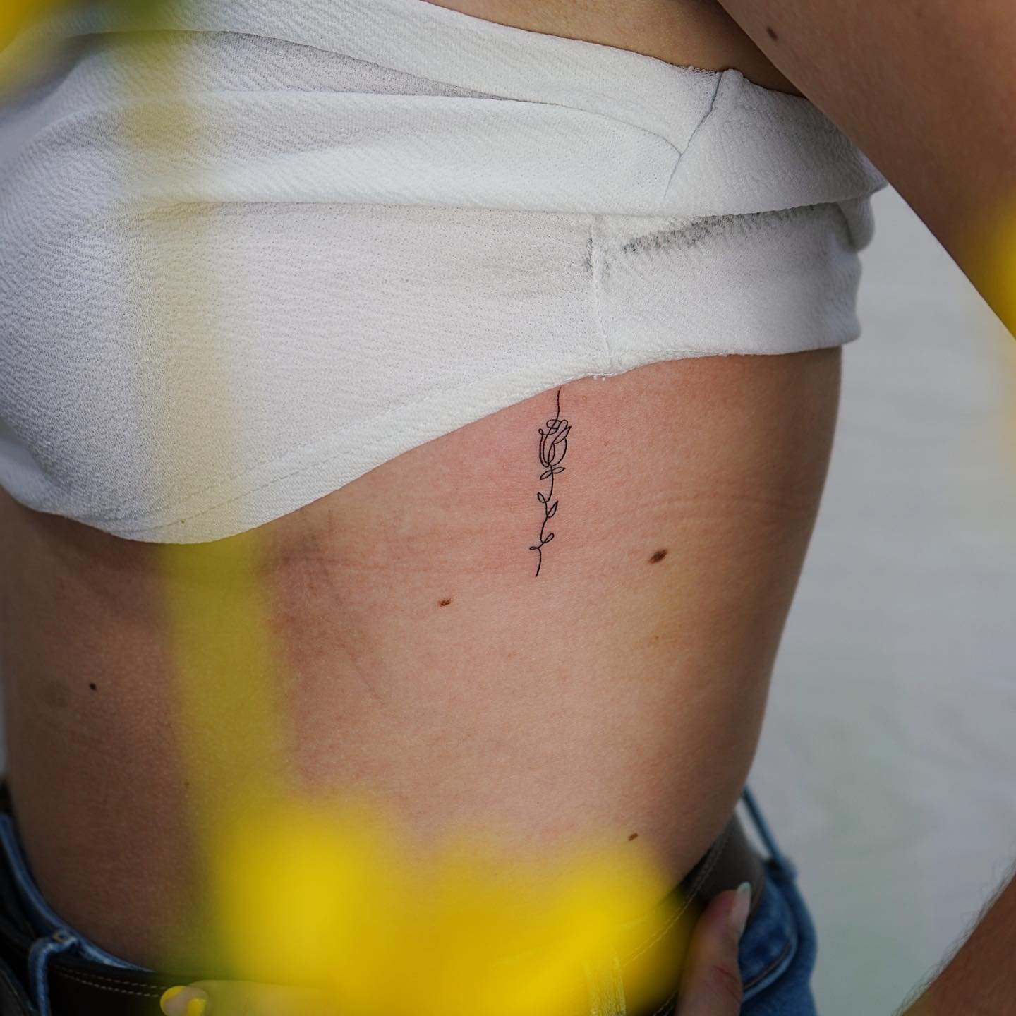 Tatuaje de frase en costilla, línea fina Sinkply Madrid