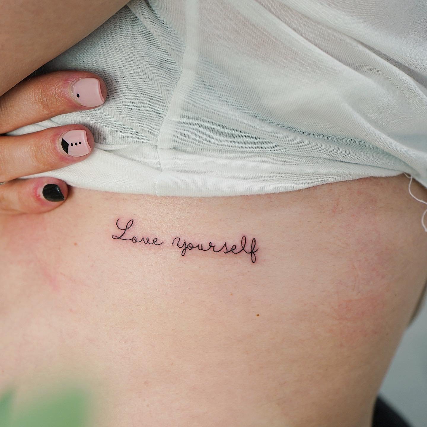 Tatuaje de frase en costilla, línea fina Sinkply Madrid