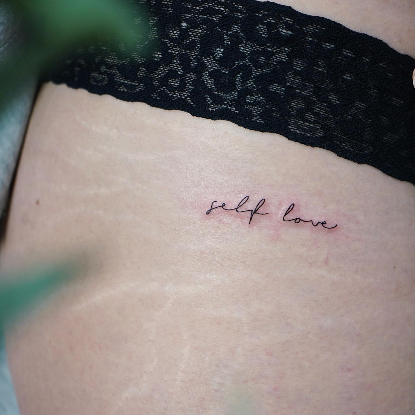 Tatuaje de frase en costilla, línea fina Sinkply Madrid