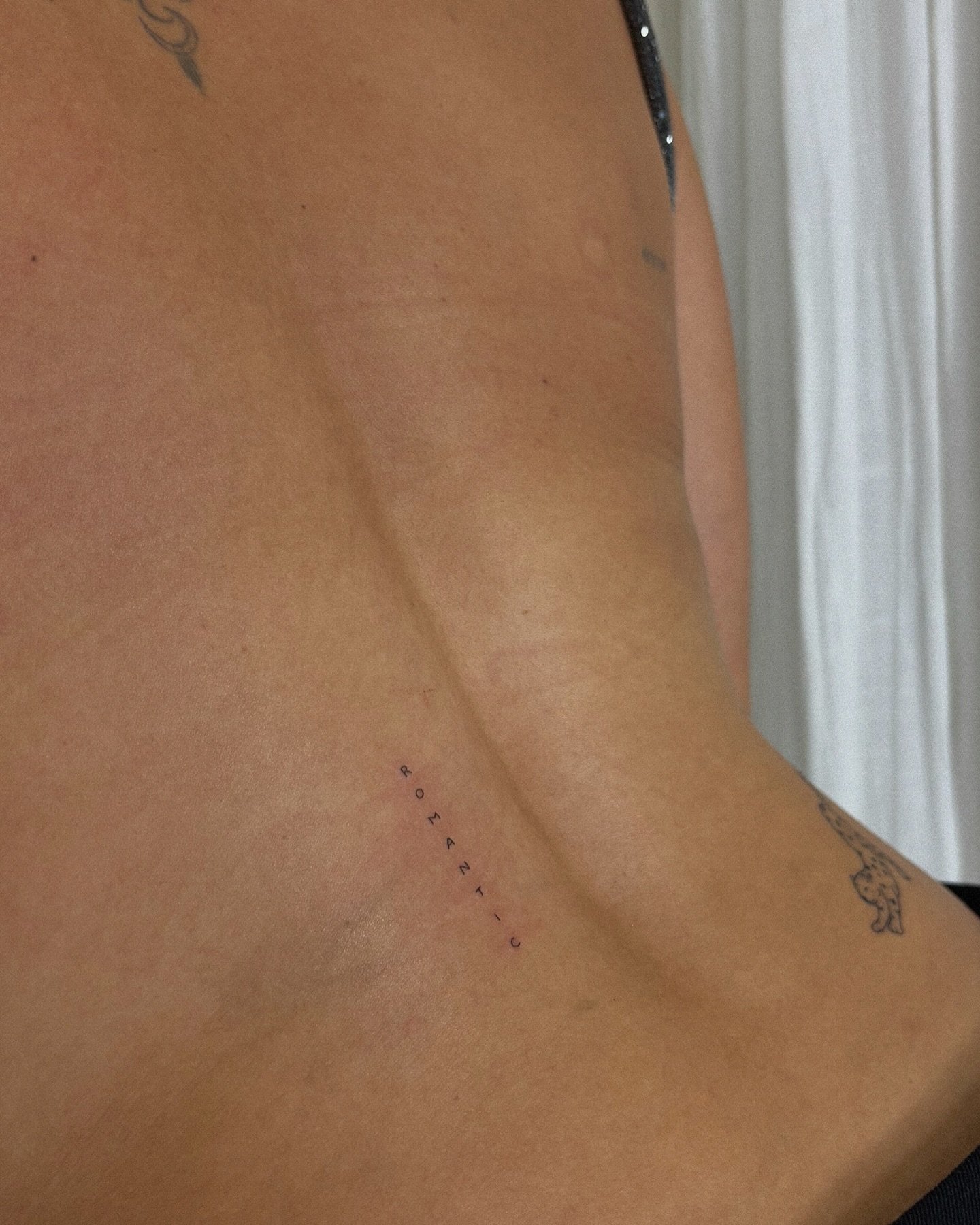 Tatuaje de frase en costilla, línea fina Sinkply Madrid