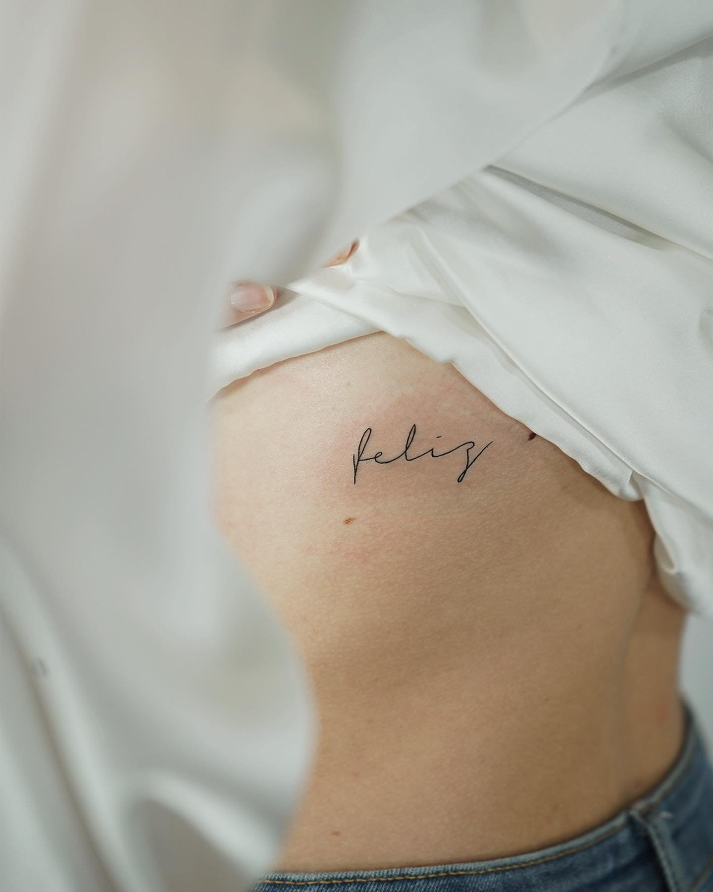 Tatuaje de frase en costilla, línea fina Sinkply Madrid