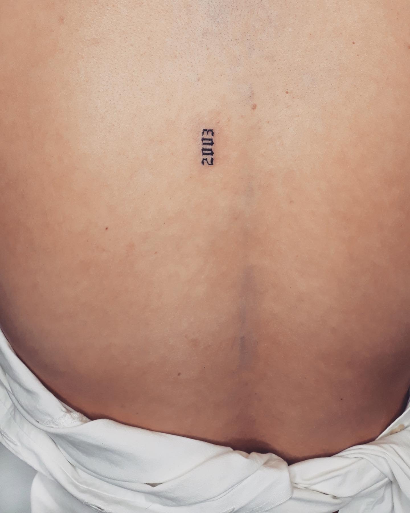 Tatuaje de frase en espalda, línea fina Sinkply Madrid