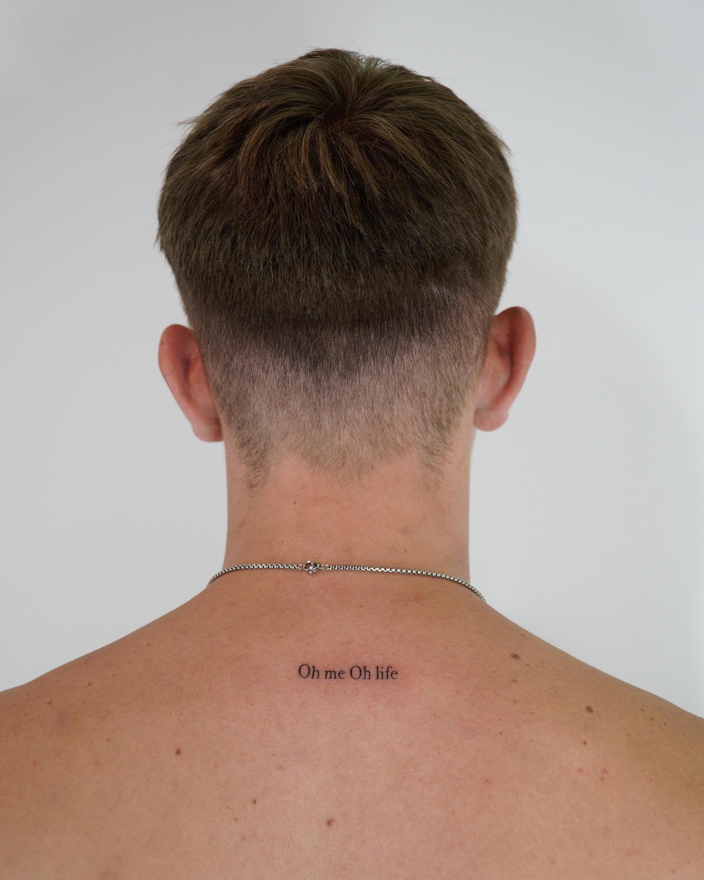 Tatuaje de frase en espalda, línea fina Sinkply Madrid