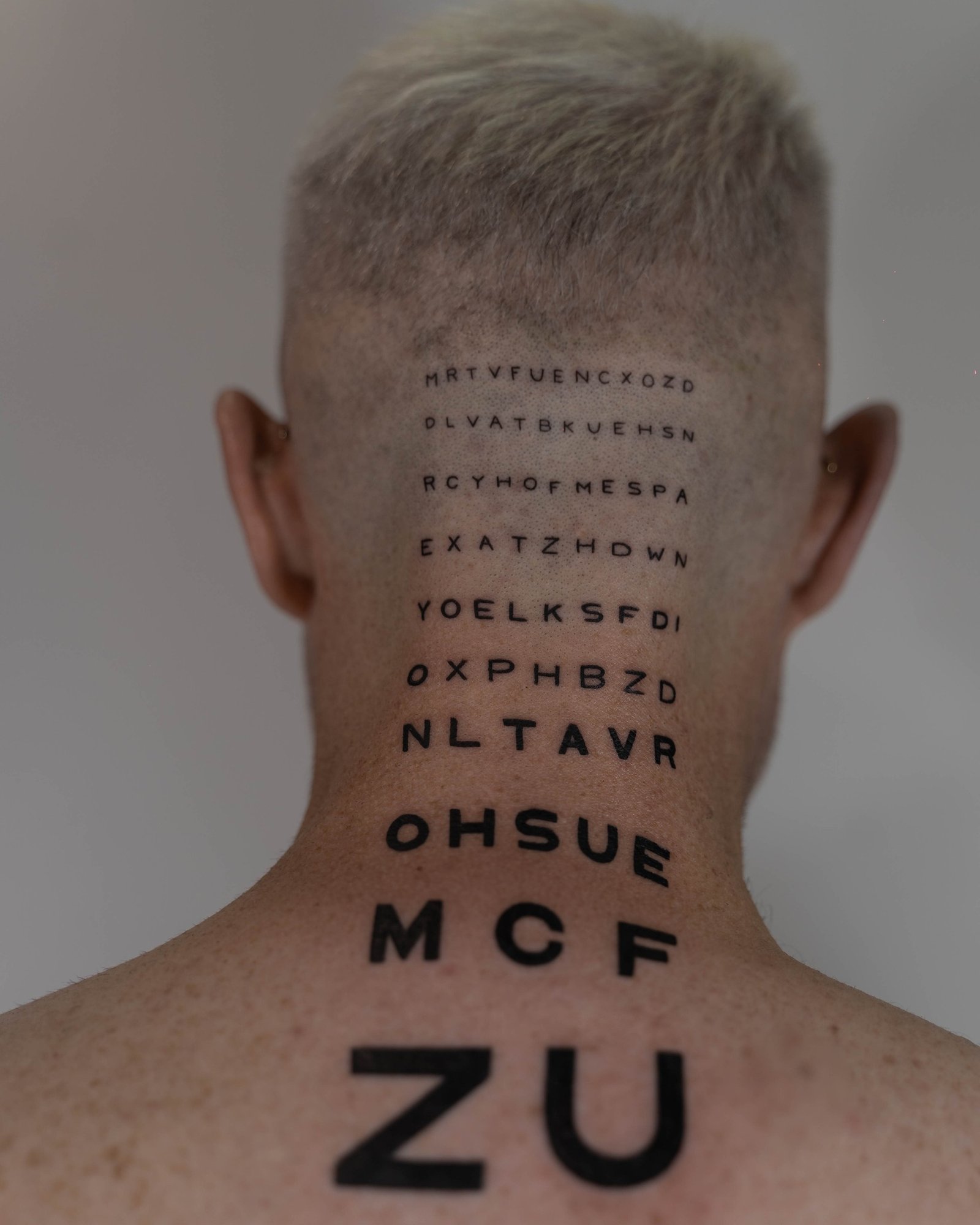 Tatuaje de frase en espalda, línea fina Sinkply Madrid