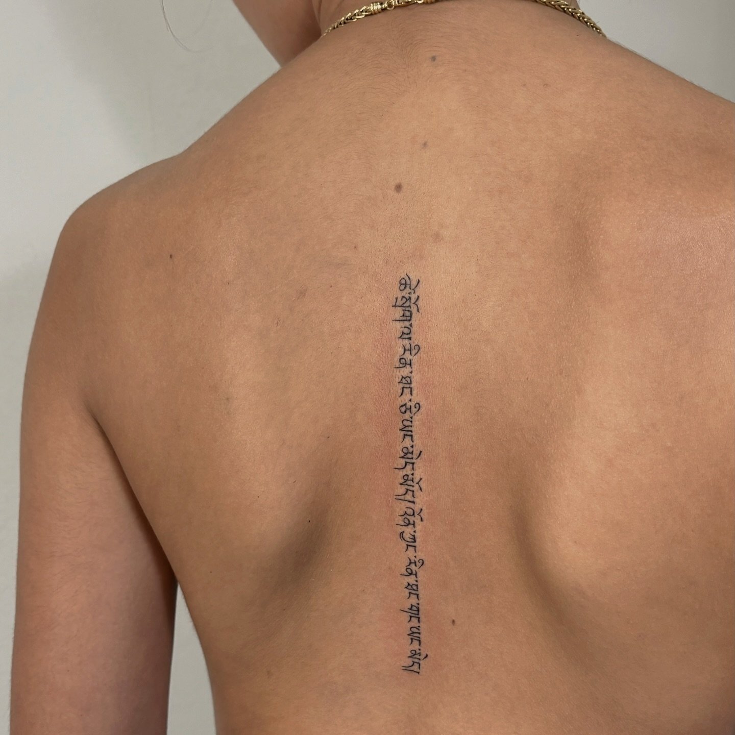 Tatuaje de frase en espalda, línea fina Sinkply Madrid