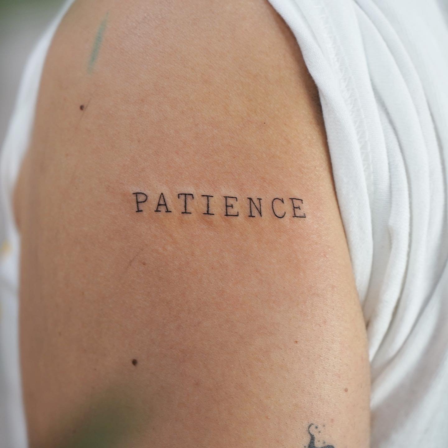 Tatuaje de frase en hombro, línea fina Sinkply Madrid