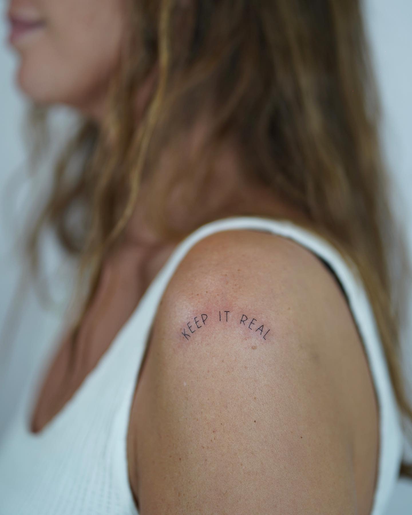 Tatuaje de frase en hombro, línea fina Sinkply Madrid