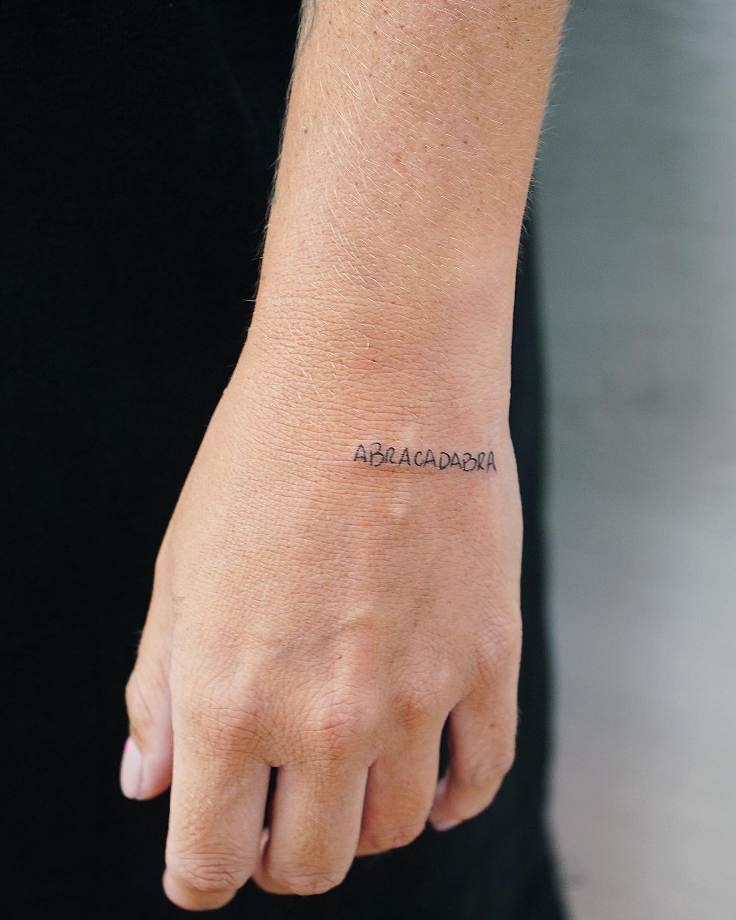 Tatuaje de frase en mano, línea fina Sinkply Madrid