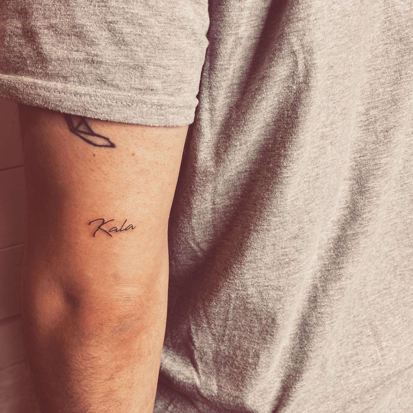 Tatuaje de frase en muslo, línea fina Sinkply Madrid