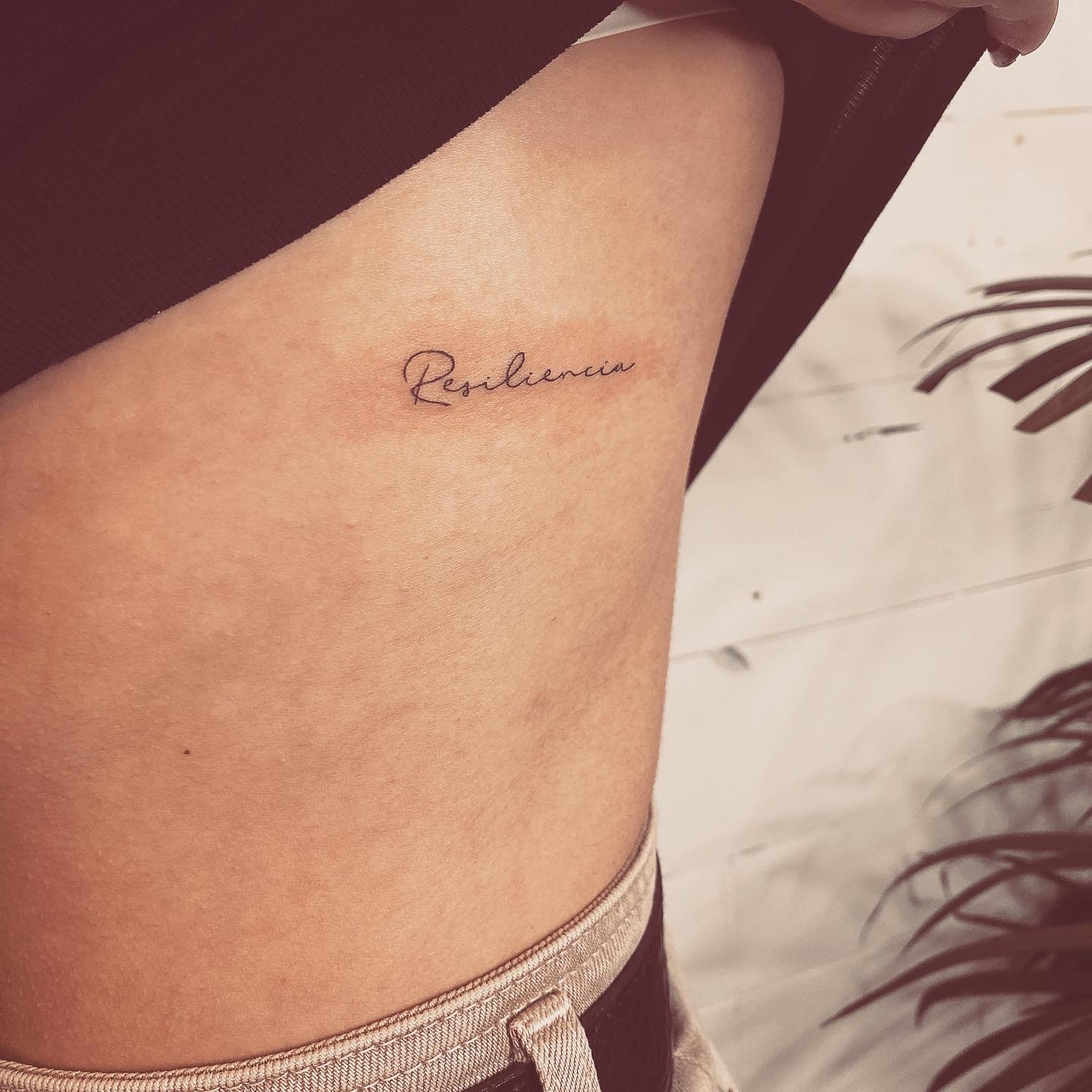Tatuaje de frase en muslo, línea fina Sinkply Madrid