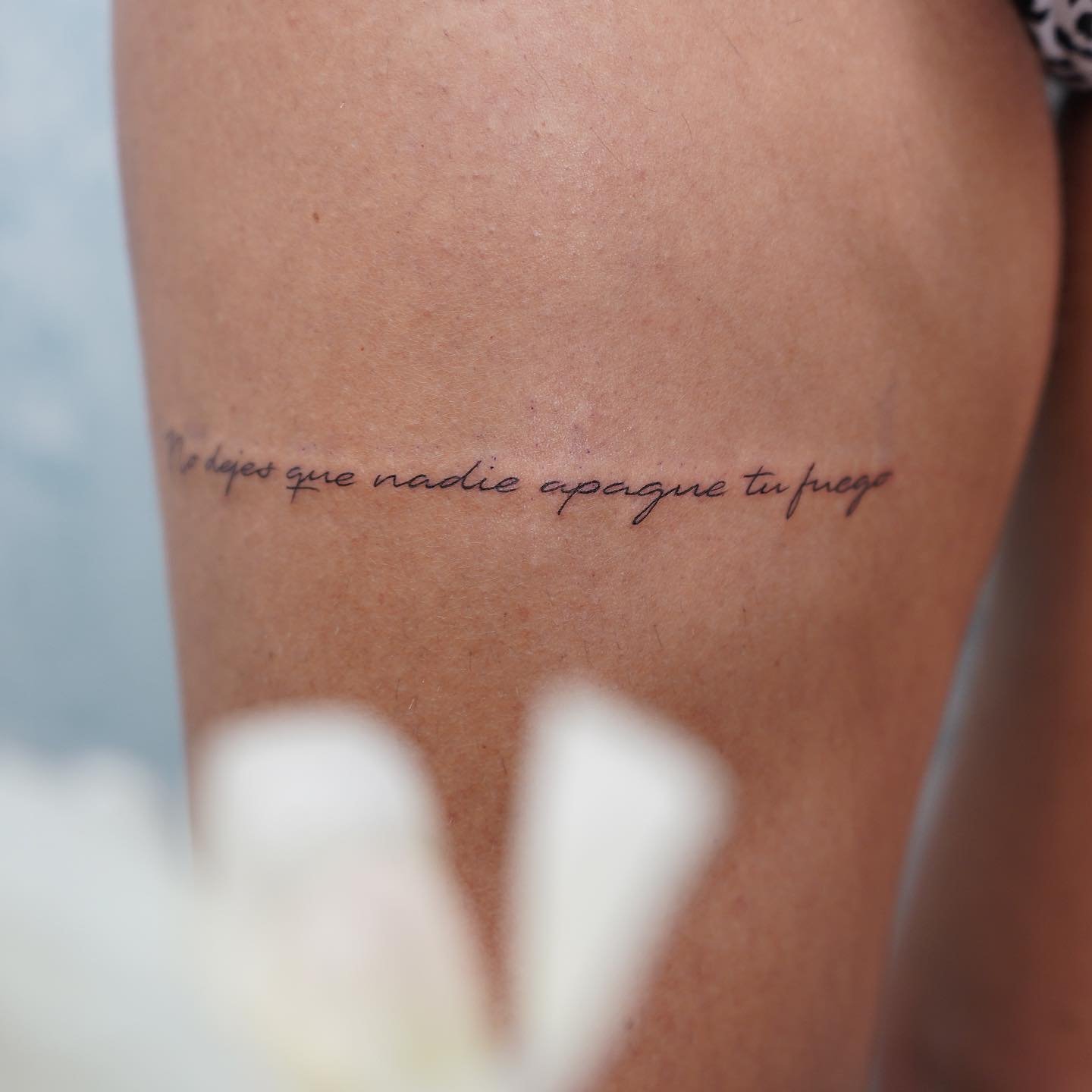 Tatuaje de frase en muslo, línea fina Sinkply Madrid
