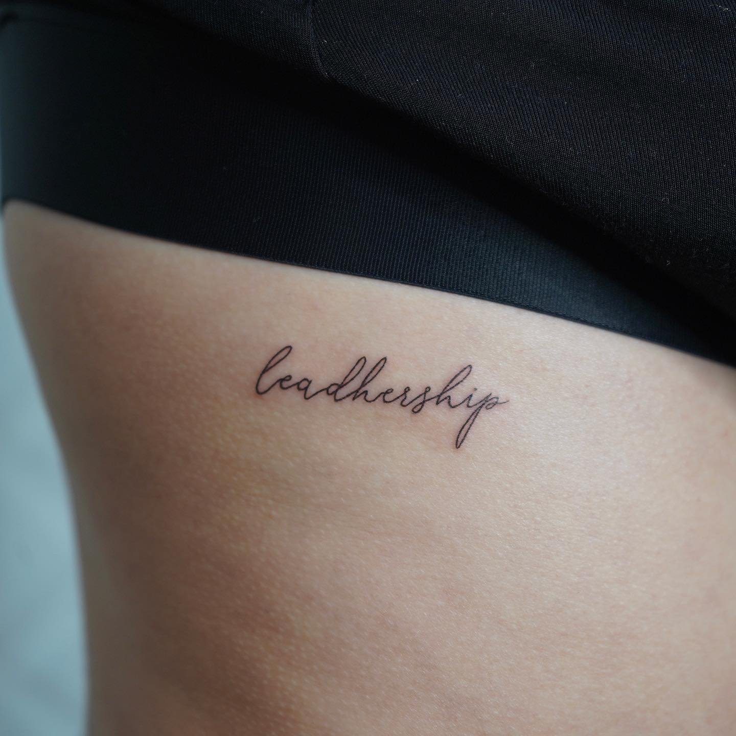 Tatuaje de frase en muslo, línea fina Sinkply Madrid