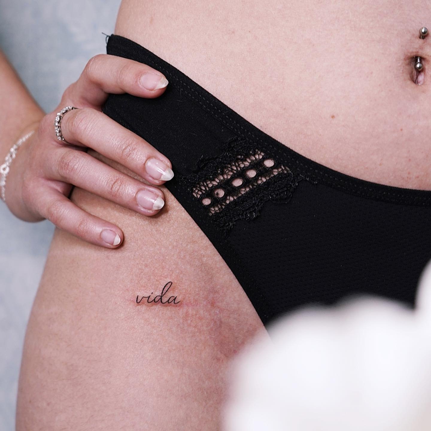 Tatuaje de frase en muslo, línea fina Sinkply Madrid