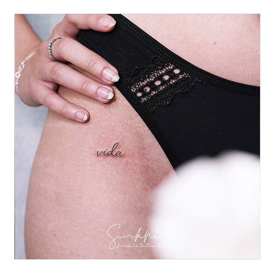 Tatuaje de frase en muslo, línea fina Sinkply Madrid