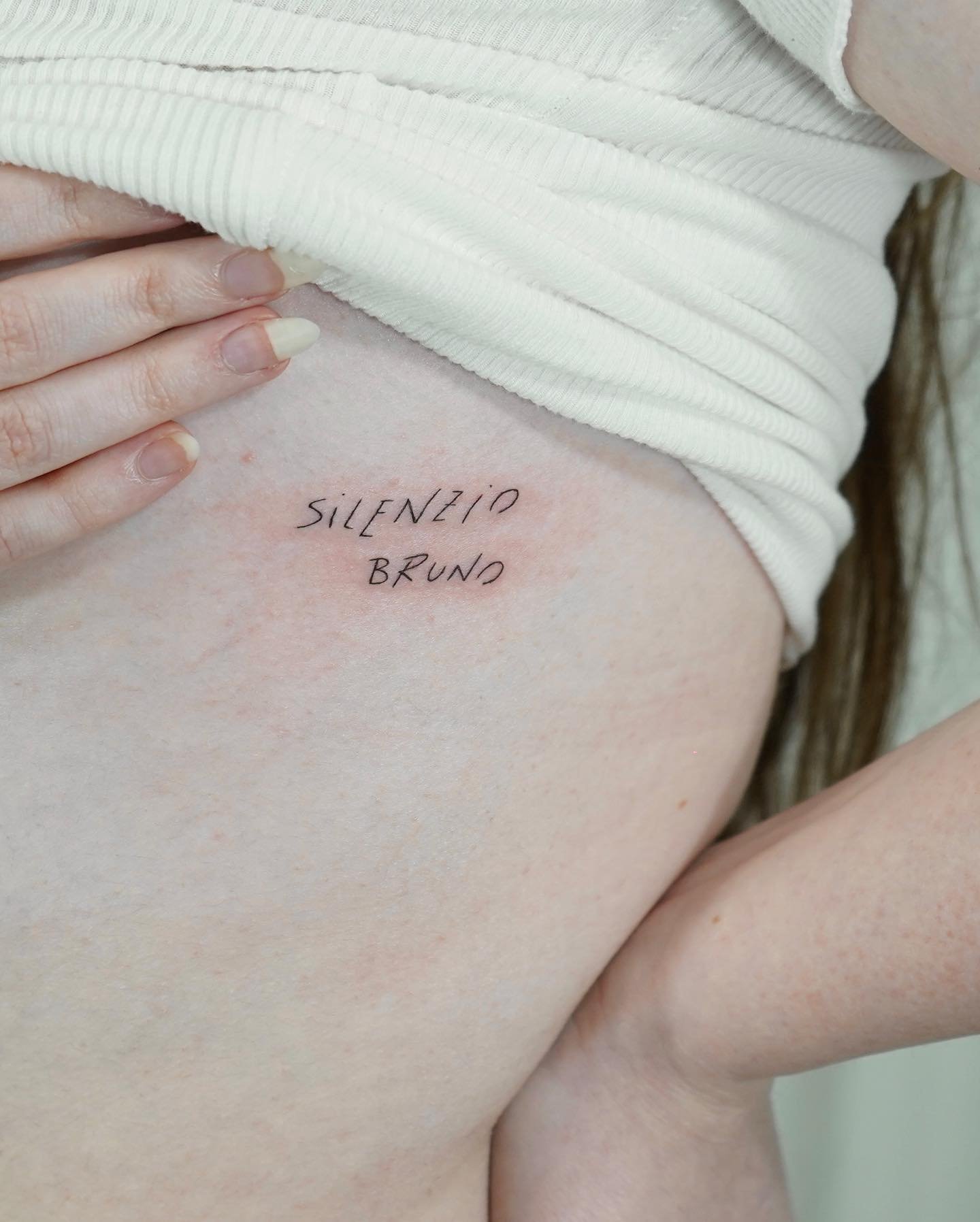 Tatuaje de frase en muslo, línea fina Sinkply Madrid