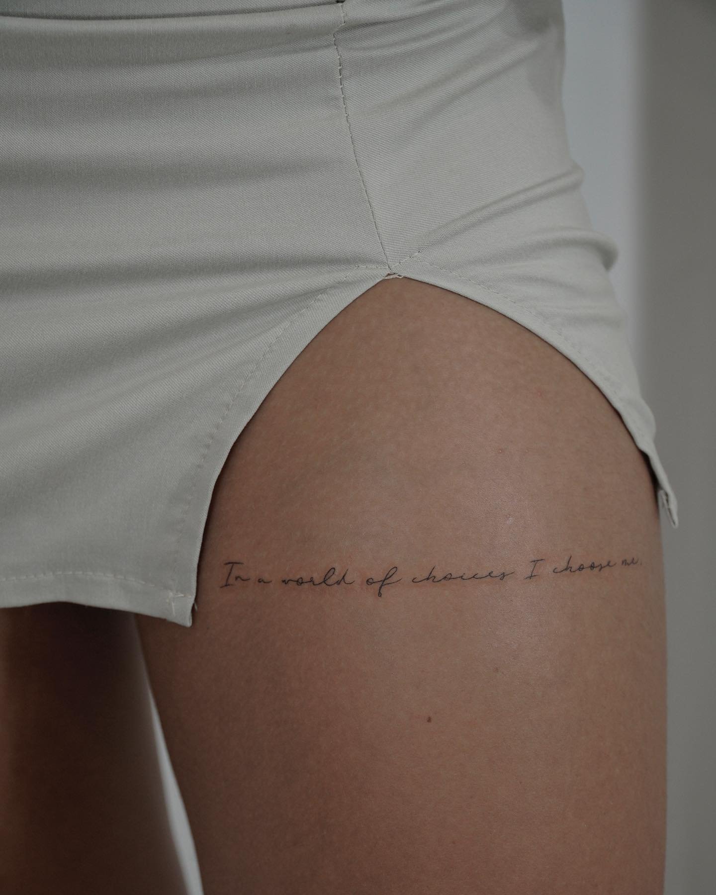Tatuaje de frase en muslo, línea fina Sinkply Madrid