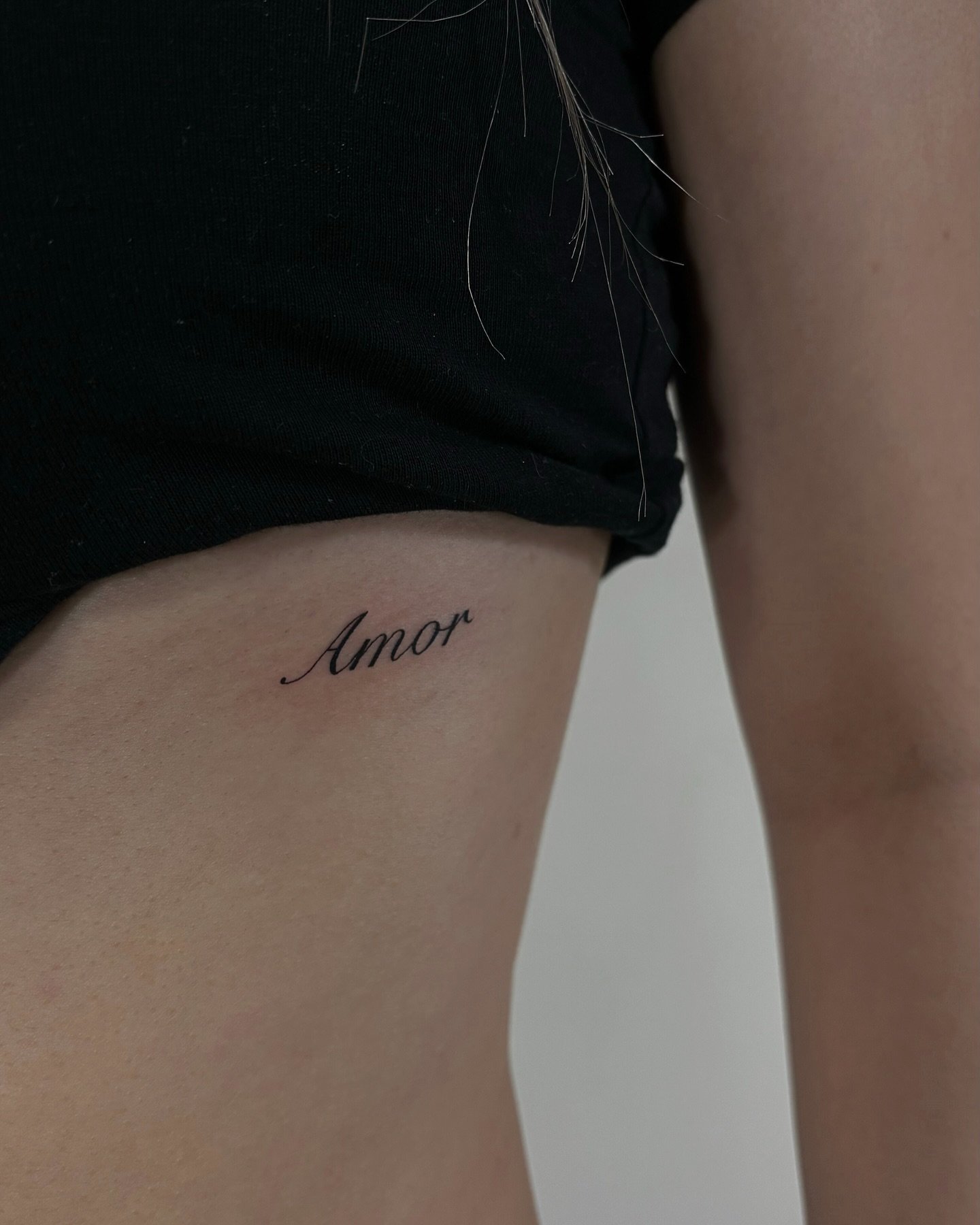Tatuaje de frase en muslo, línea fina Sinkply Madrid