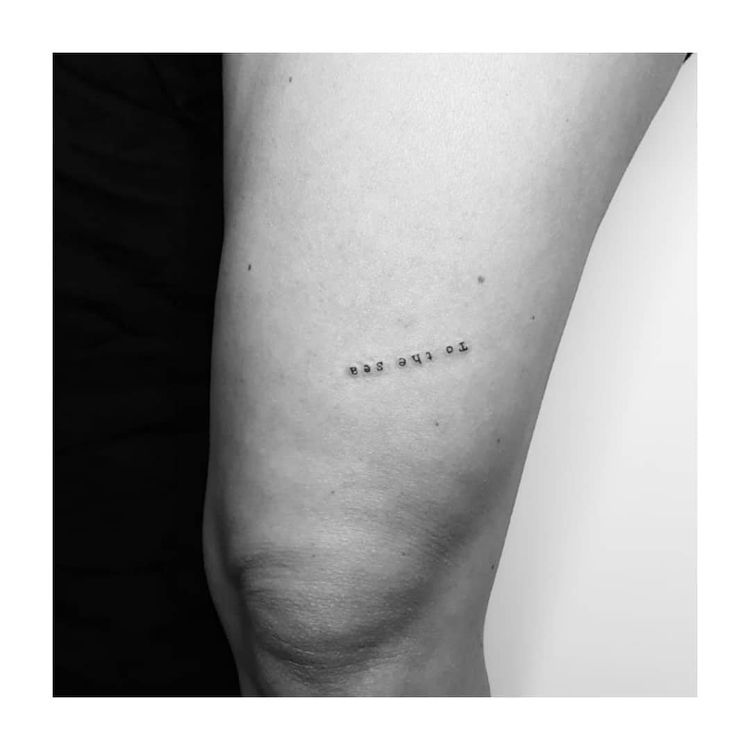 Tatuaje de frase en muslo, línea fina Sinkply Madrid