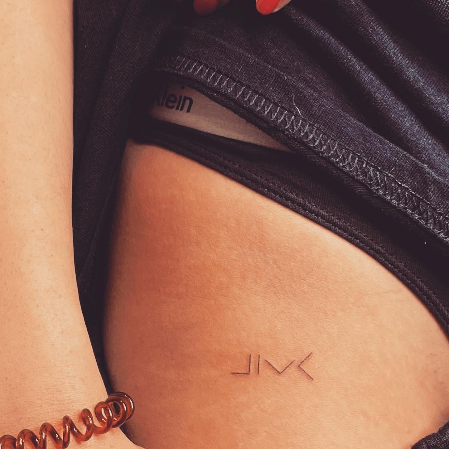 Tatuaje de frase en muslo, línea fina Sinkply Madrid